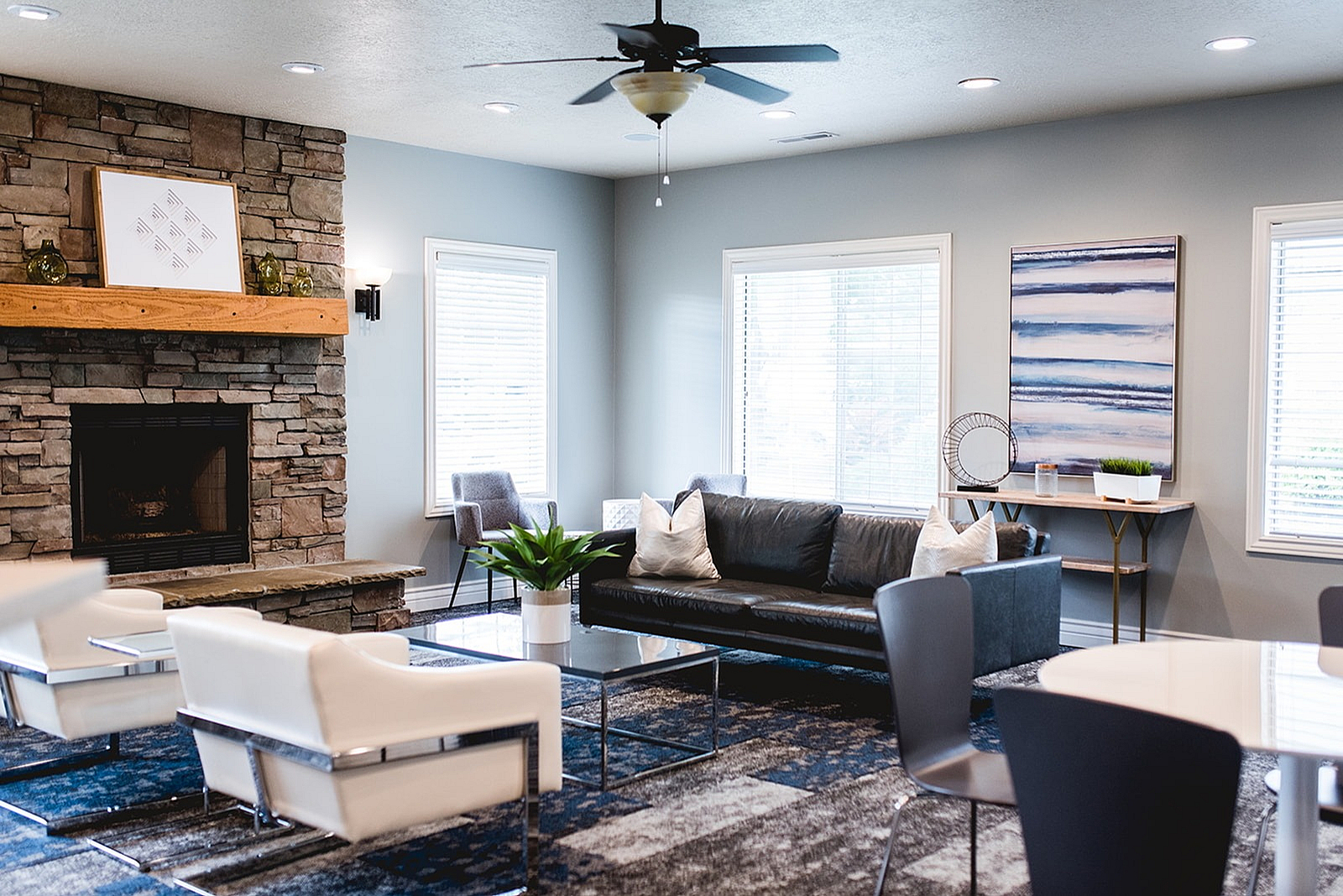 Charming living room with a cozy stone fireplace, sleek modern furniture, and ample natural light.
