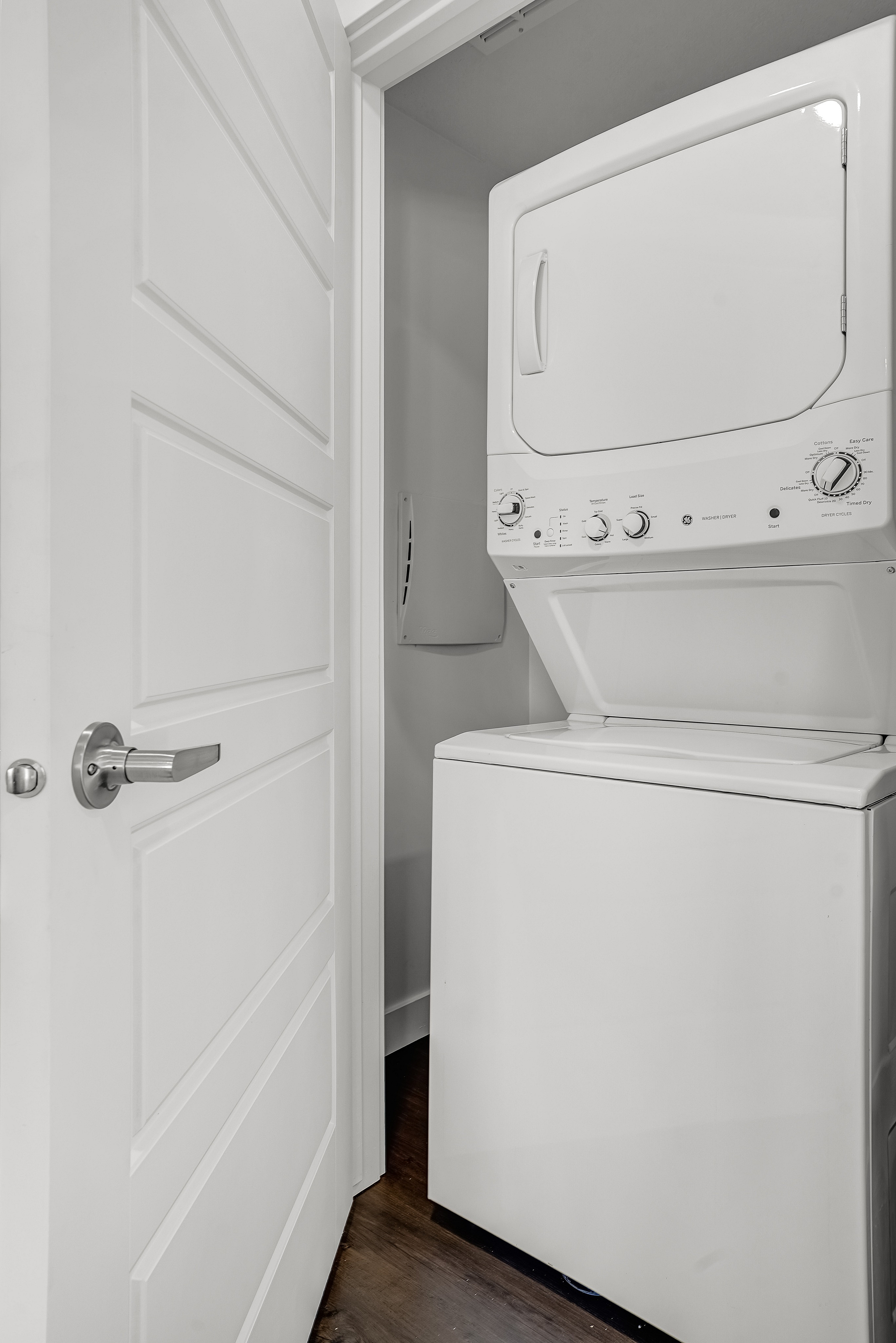 Modern apartment laundry room with stacked washer and dryer, sleek design, and efficient use of space.