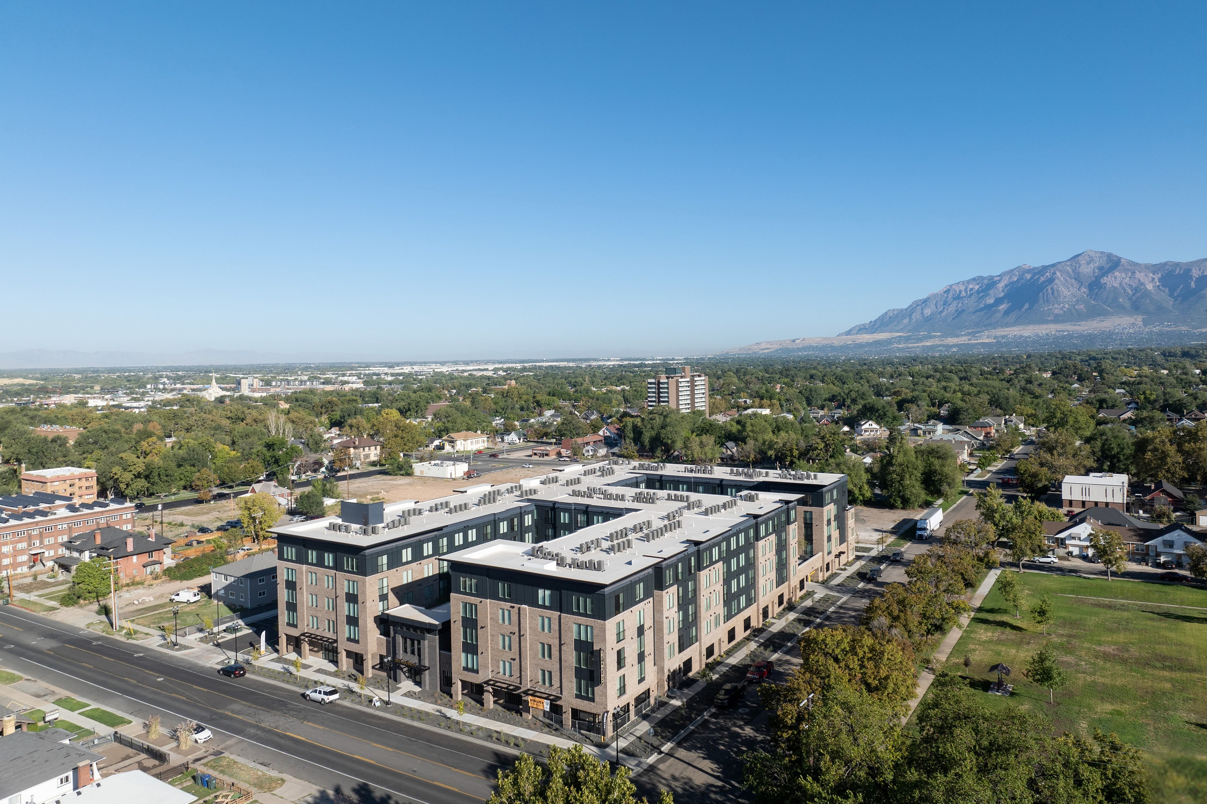 Modern apartment complex with scenic mountain views and lush green surroundings, perfect for serene urban living.