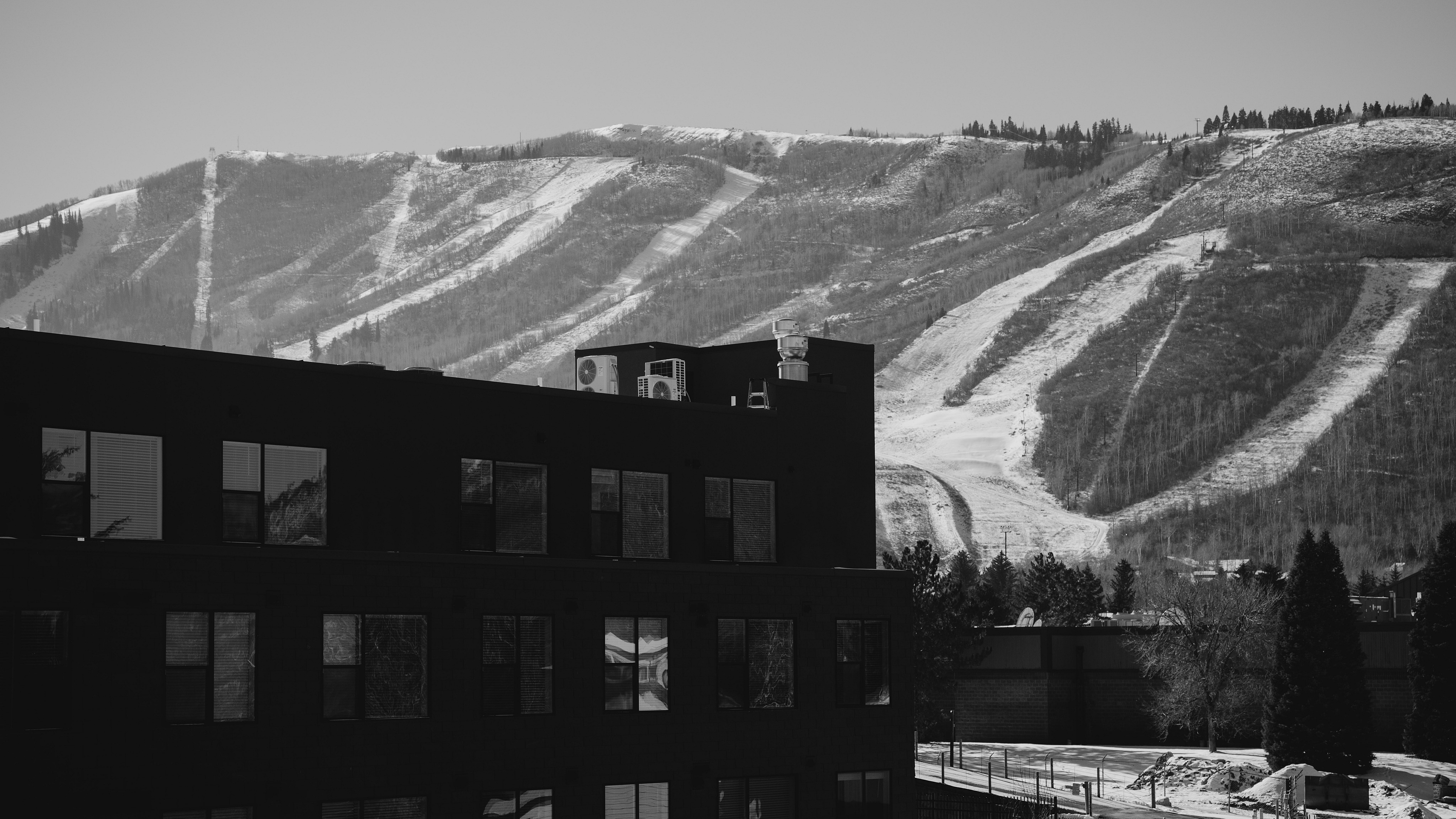 Enchanting snow-capped mountains form a stunning backdrop to modern apartment architecture, offering a unique blend of nature and urban living.