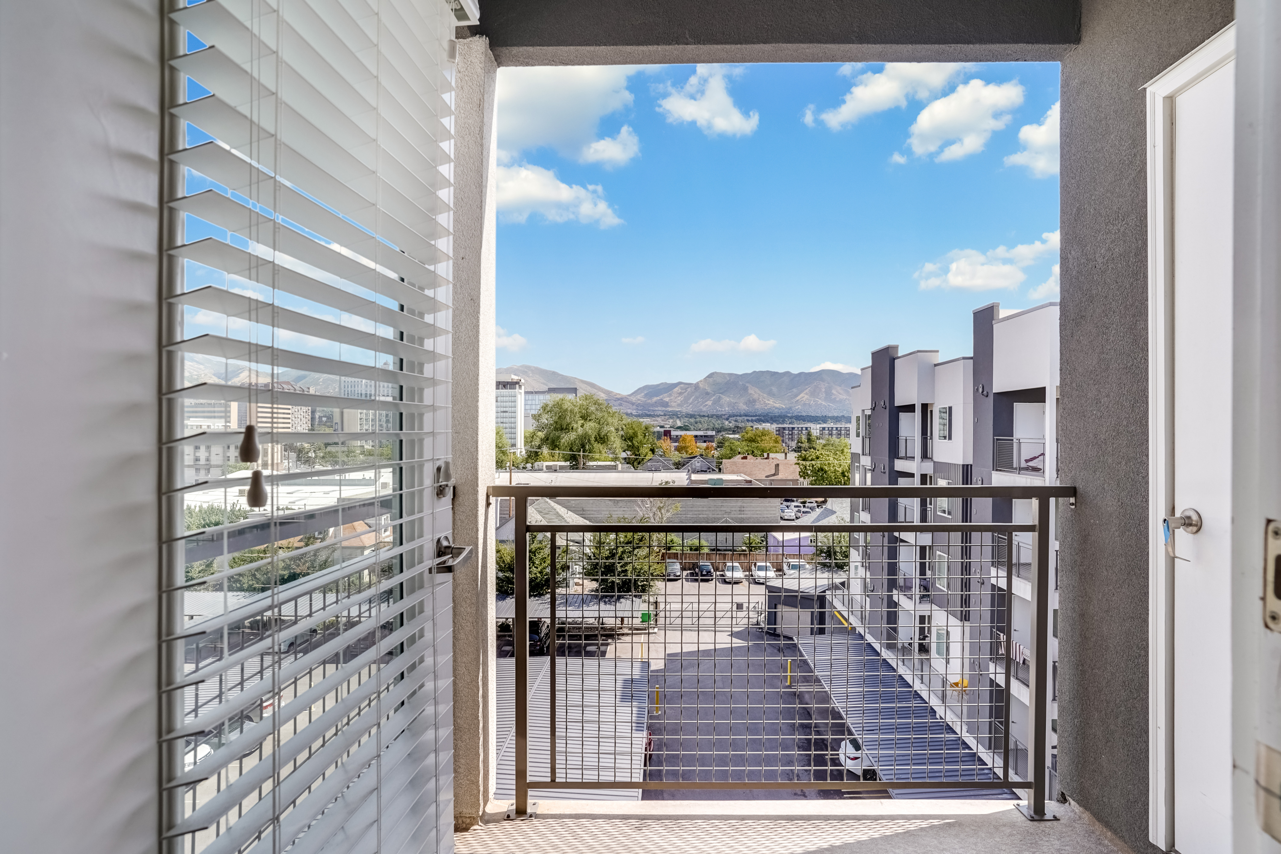 Bright balcony view offering picturesque mountain vistas and modern cityscape, perfect for relaxation.