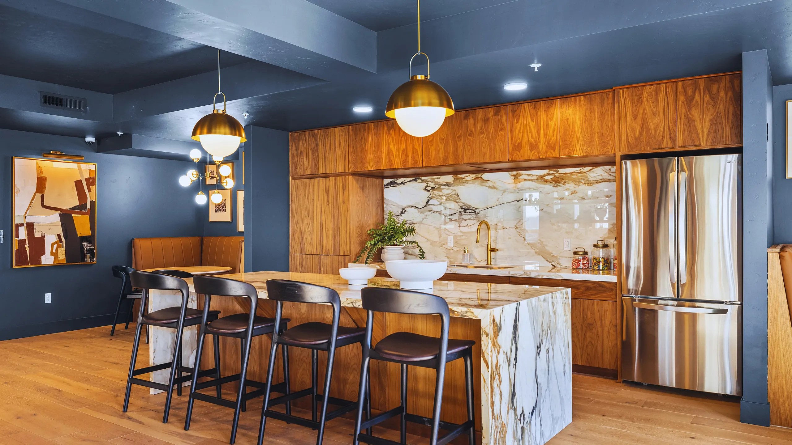 Sleek modern kitchen with marble island, wood cabinetry, and elegant lighting.