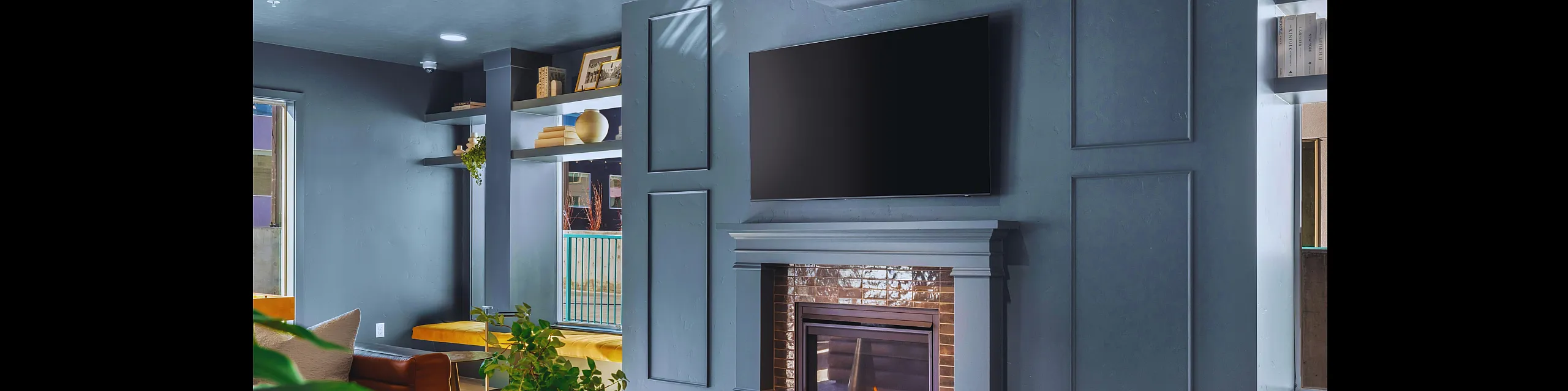 Chic modern living room with a cozy fireplace, elegant shelving, and plush seating, perfect for relaxation.