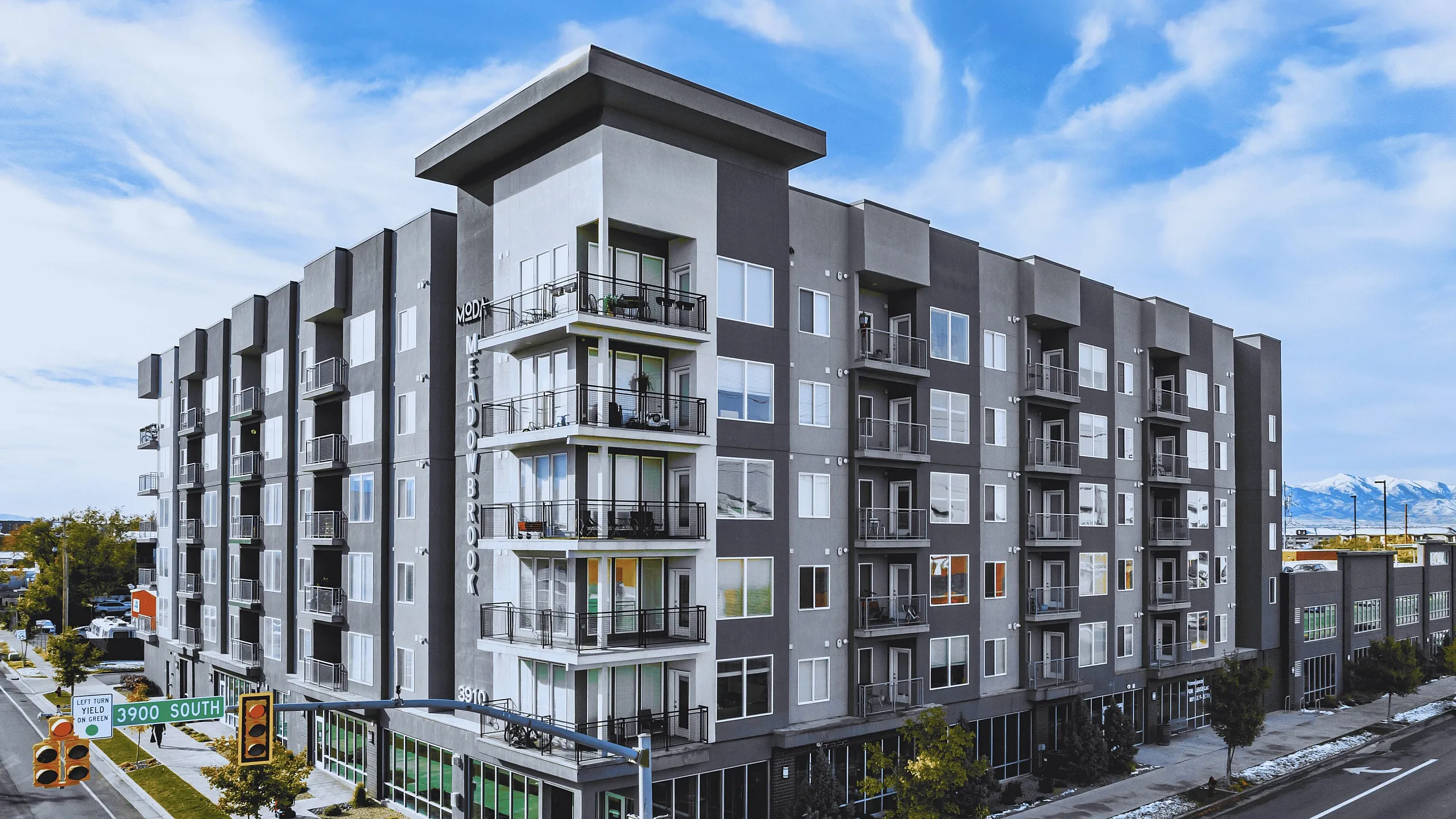 Modern apartment building with stylish design, large balconies, and panoramic views, set in a vibrant urban area.