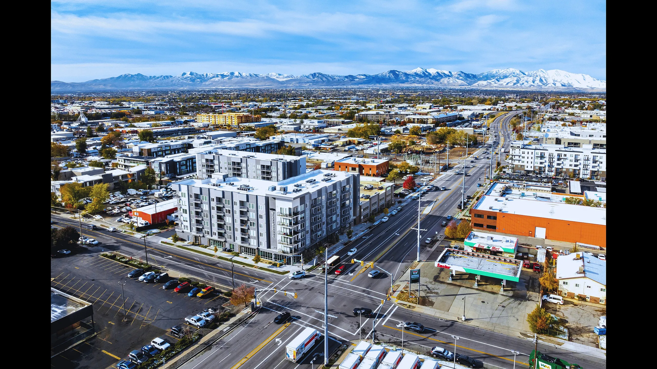 Aerial view of a modern apartment complex with breathtaking mountain views, showcasing urban convenience and scenic beauty.