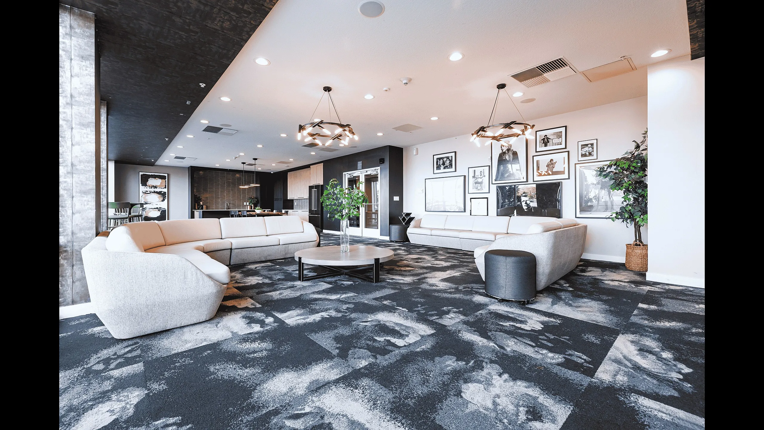 Luxurious apartment lounge with modern lighting, plush sectional sofas, and chic decor.