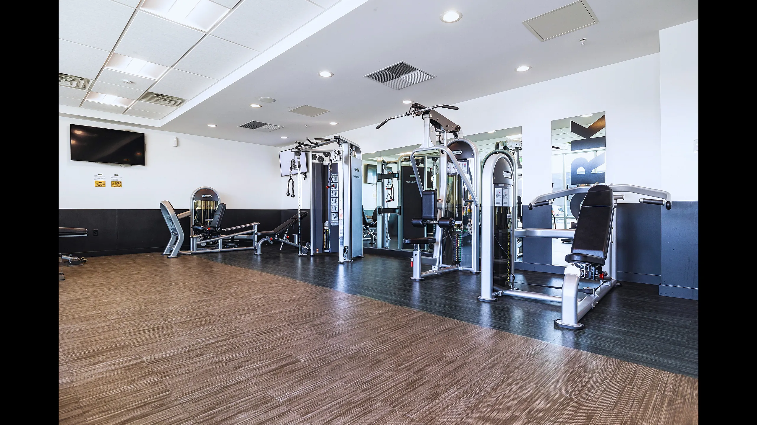 Modern apartment fitness center with state-of-the-art gym equipment, sleek design, and ample space for workouts.