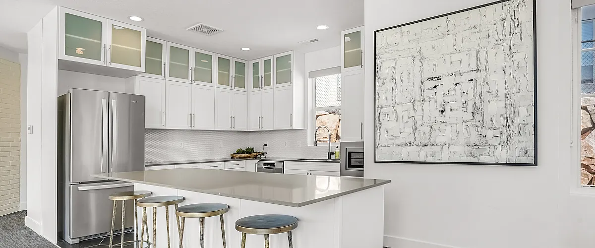 Contemporary kitchen showcasing sleek cabinetry, stainless steel appliances, and a spacious breakfast bar with stylish stools.