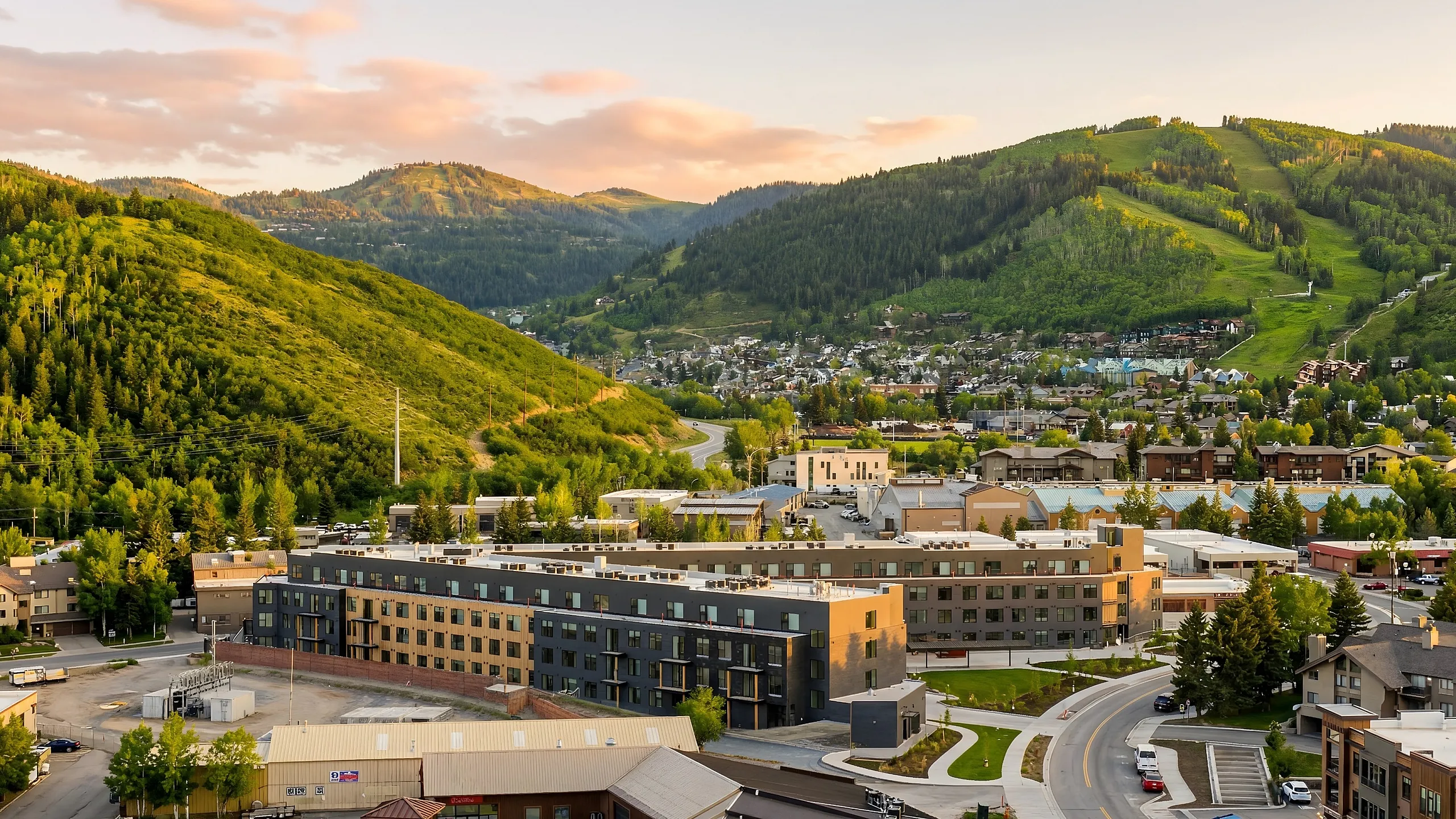 Captivating mountain view apartment complex nestled in lush green hills with scenic roads and modern architecture.