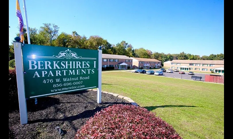 Inviting green landscape at Berkshires I Apartments with ample parking and appealing brick buildings.