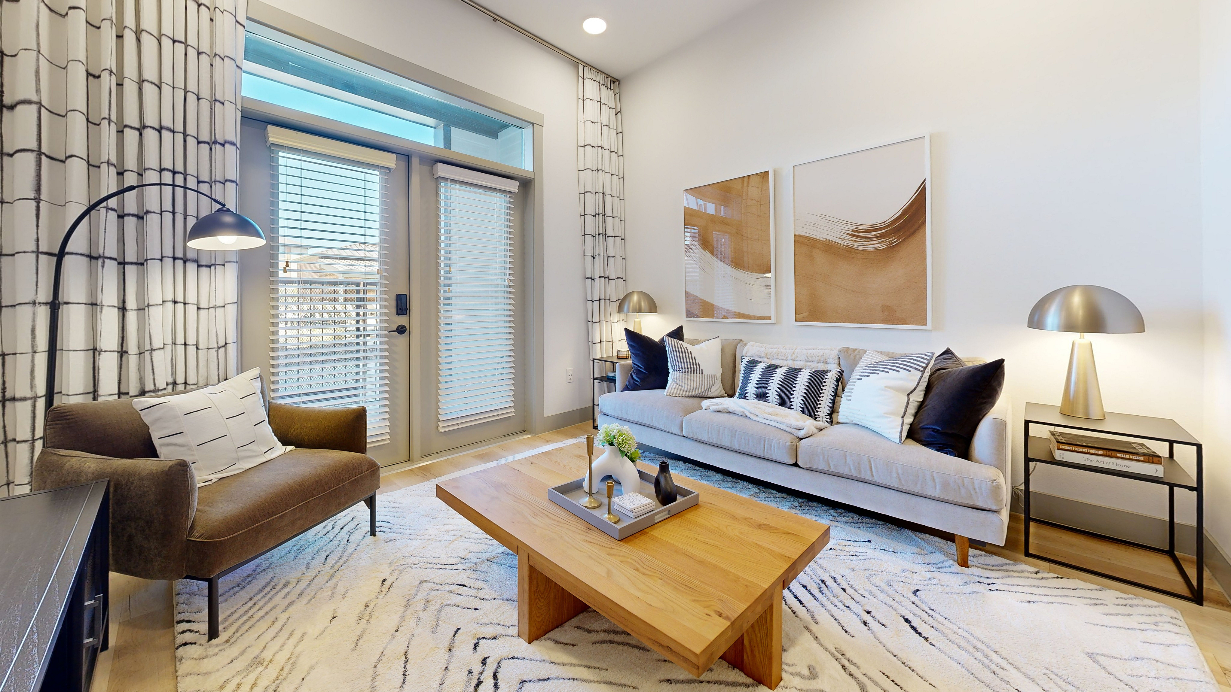 Chic living room with modern decor, featuring a cozy sofa, stylish armchair, a wooden coffee table, and lamps in Fort Worth, TX.