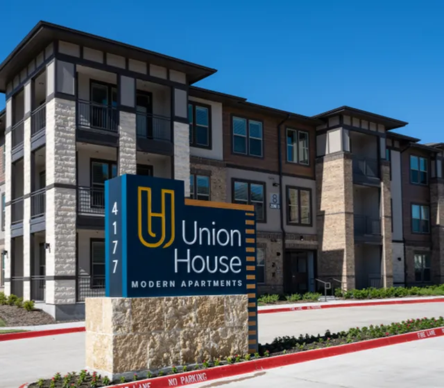 Modern Union House Apartments exterior with sleek architecture, vibrant signage, and pristine landscaping.