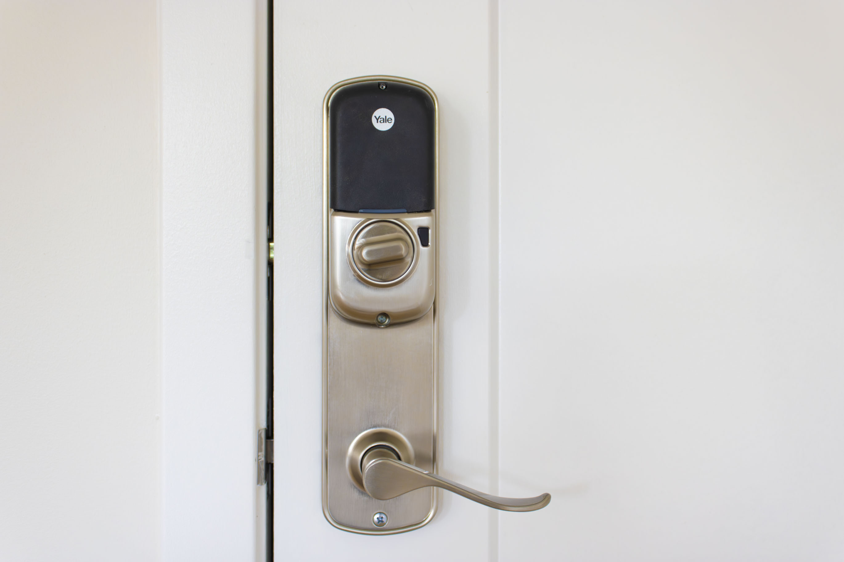 The James Apartments | Close-up of a smart Yale door lock system installed on a white door | Luxury Apartments in Haverhill MA