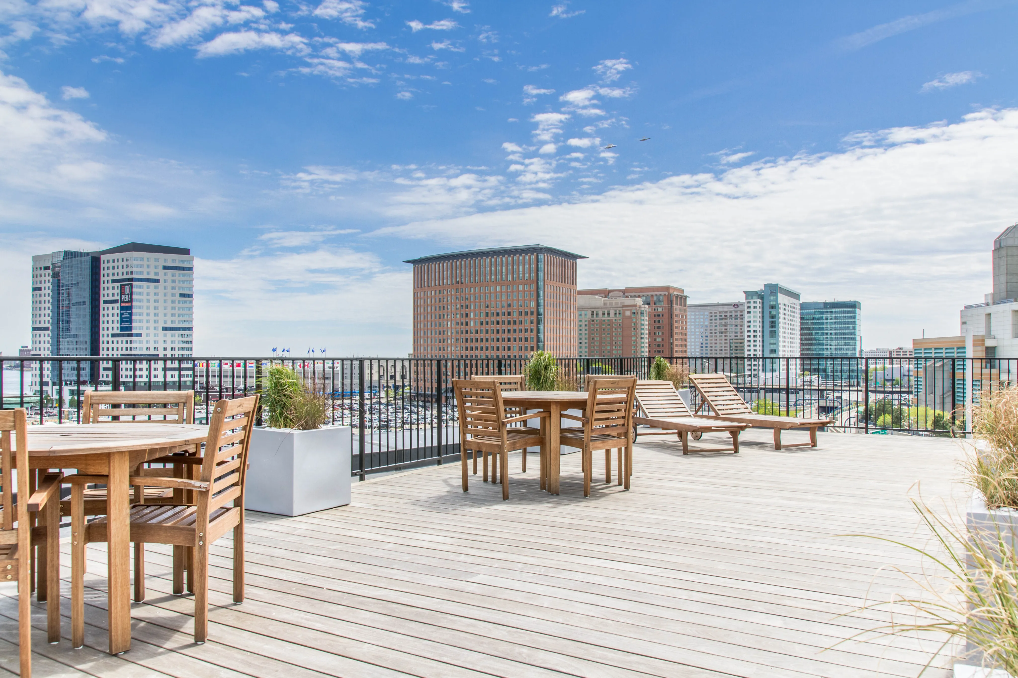 Modern rooftop terrace with wooden furniture overlooking city skyline