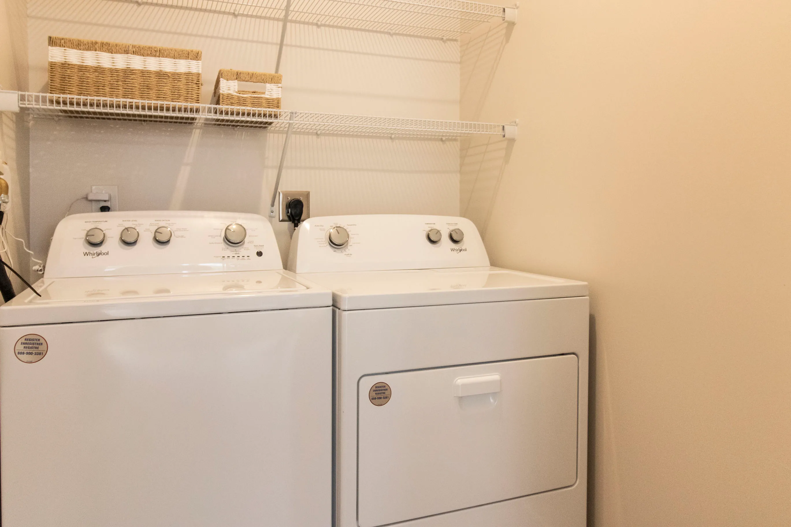 Convenient in-unit laundry room with modern washer and dryer, complemented by sleek shelving for organized storage.