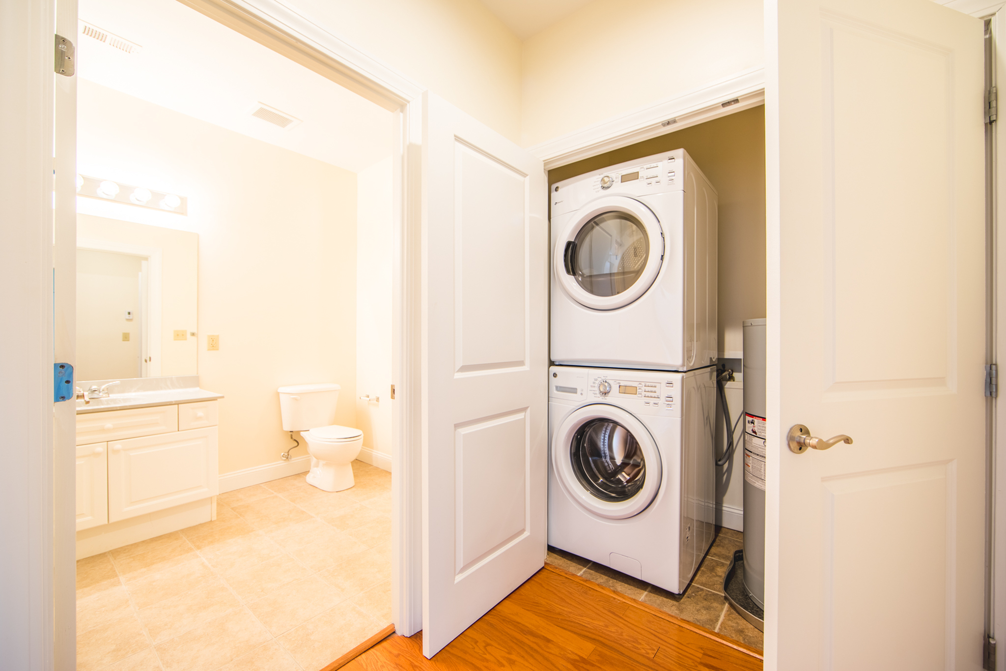 Bright, inviting apartment space featuring a modern bathroom with elegant fixtures and a convenient in-unit laundry equipped with a stacked washer and dryer.