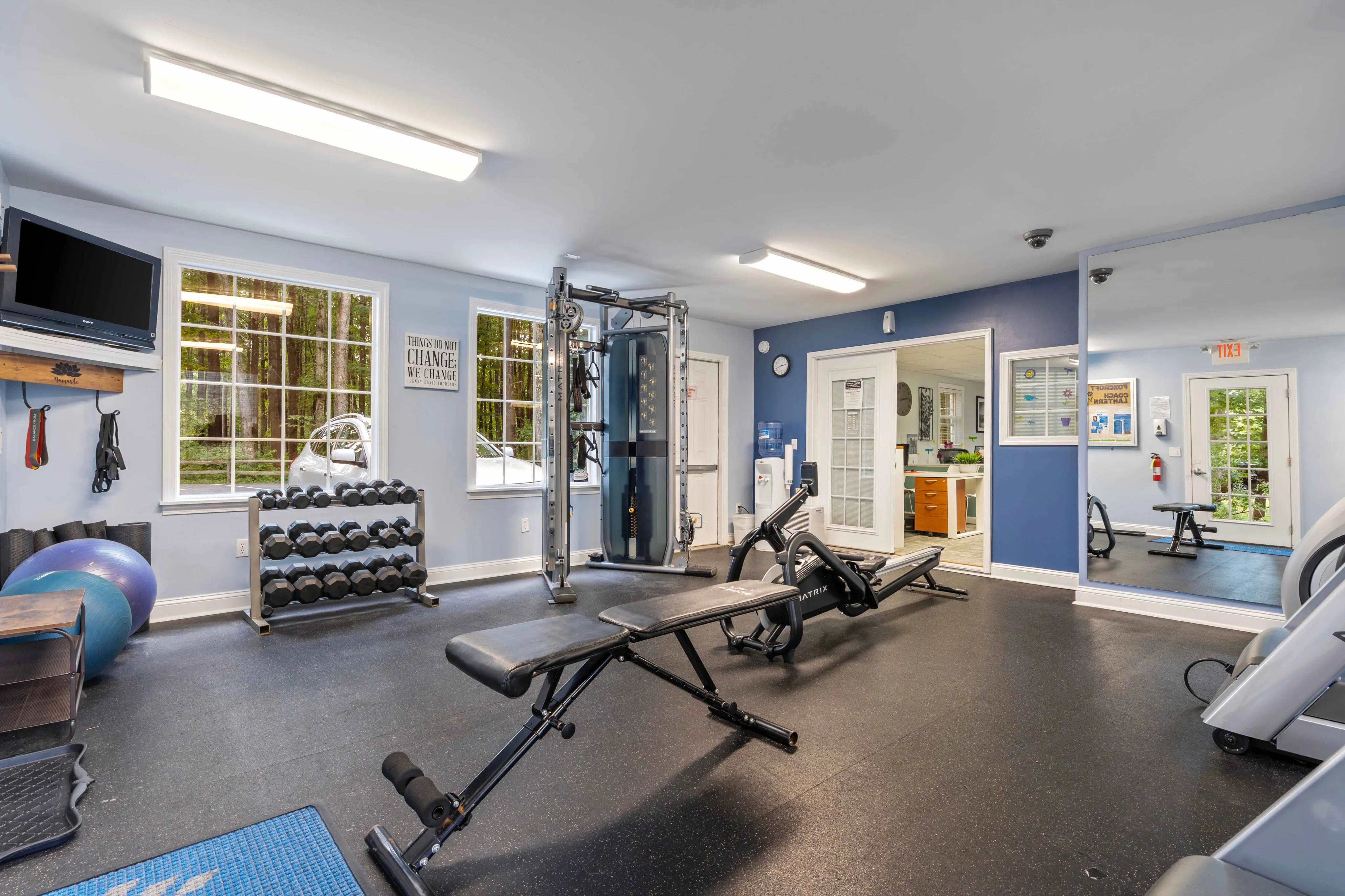 Bright and modern home gym with fitness equipment, large windows, and motivating decor.