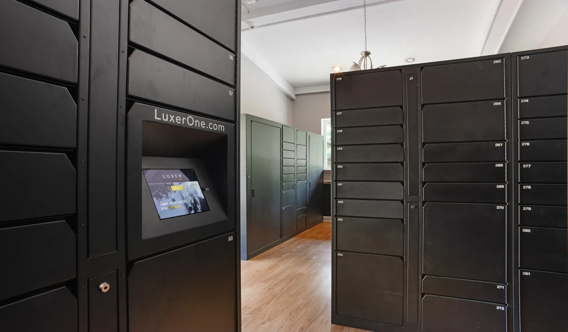 Modern apartment mailroom featuring sleek black parcel lockers with digital access for secure package storage.