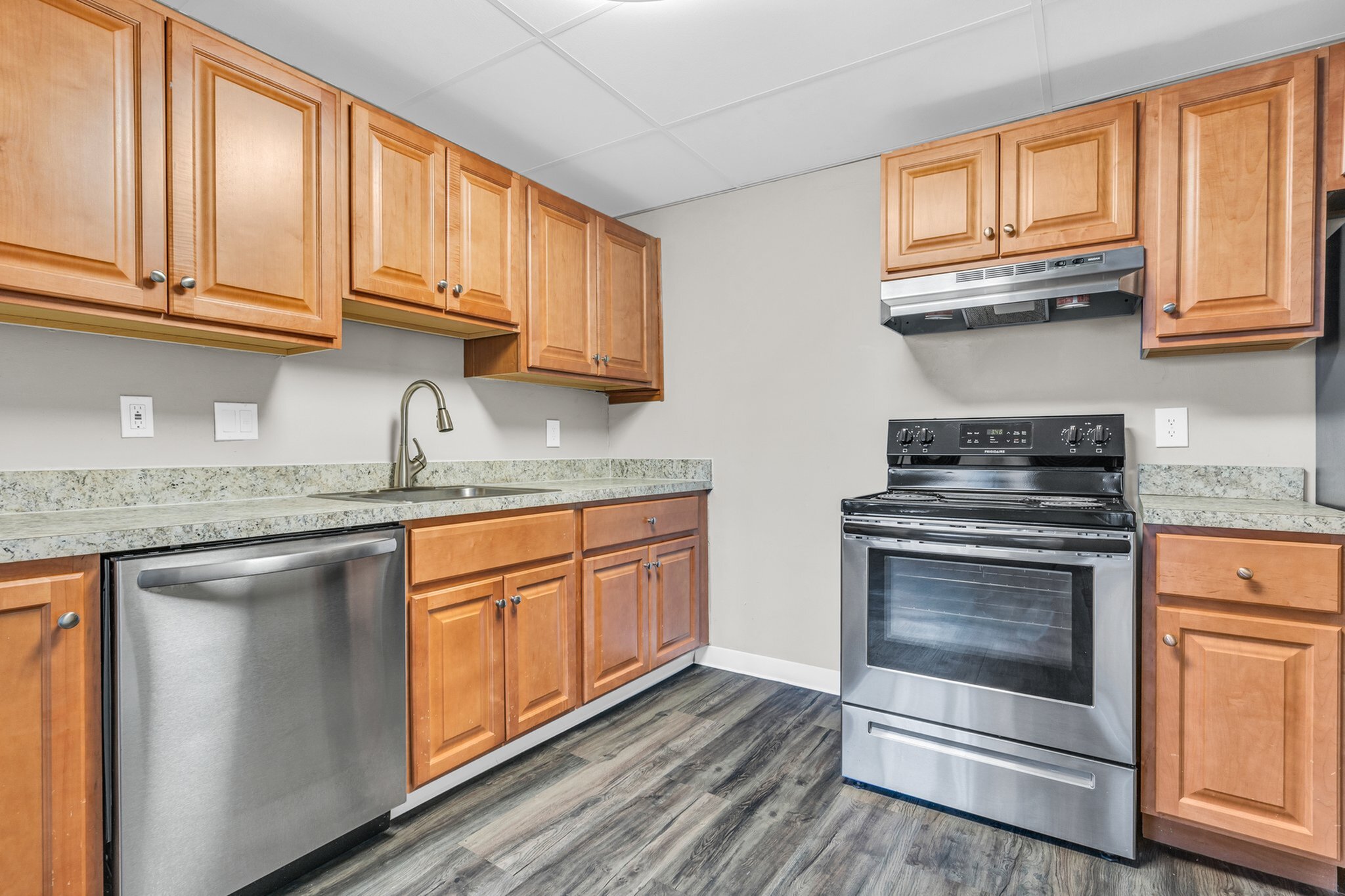 Modern kitchen with elegant wooden cabinetry, sleek stainless steel appliances, and stylish granite countertops, perfect for culinary enthusiasts.