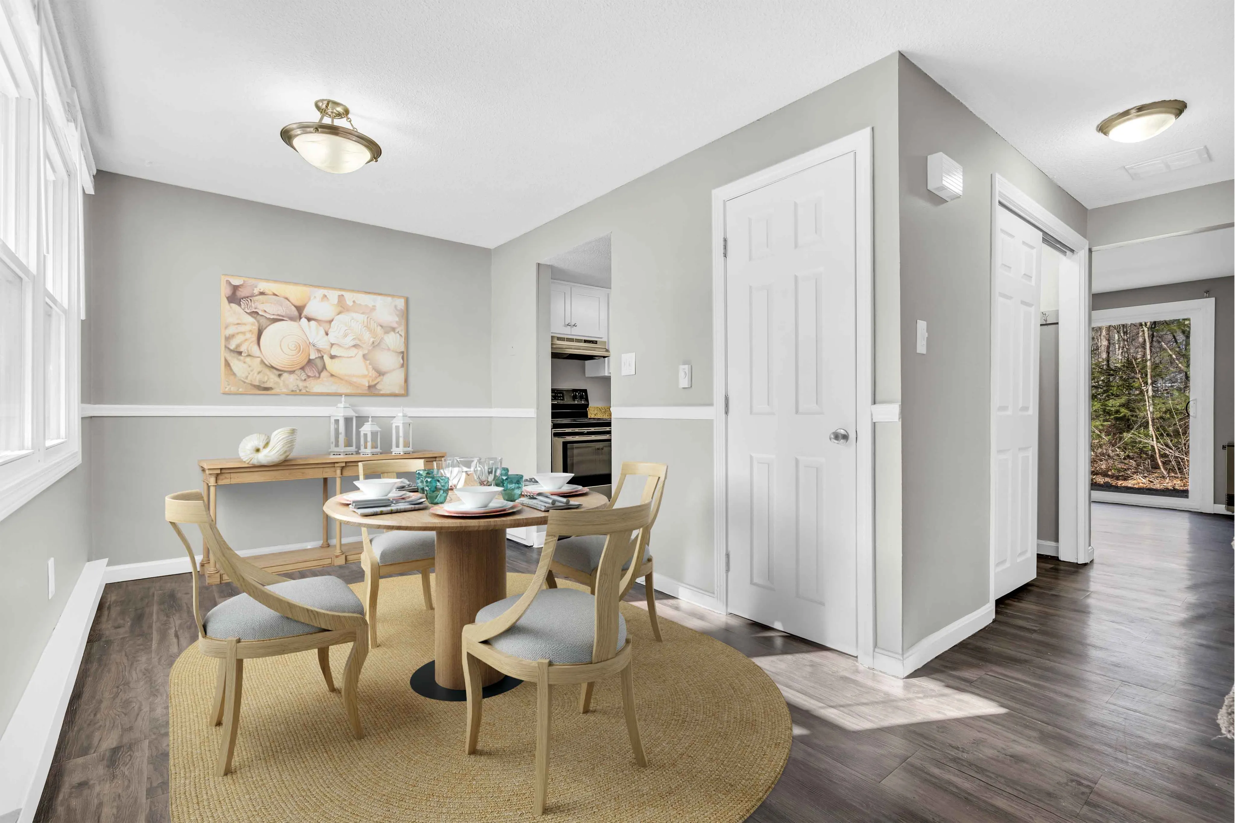 Bright and cozy dining area with elegant table setting, featuring soft natural light and a view into the modern kitchen.
