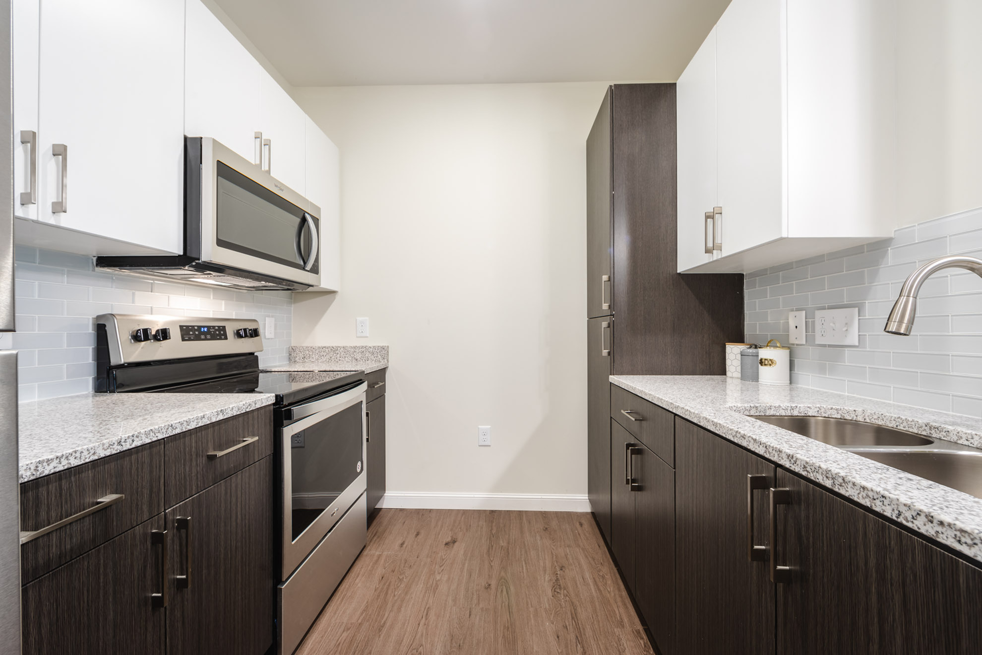 Modern kitchen with sleek stainless steel appliances, granite countertops, and elegant wood cabinetry, creating a stylish and functional space.