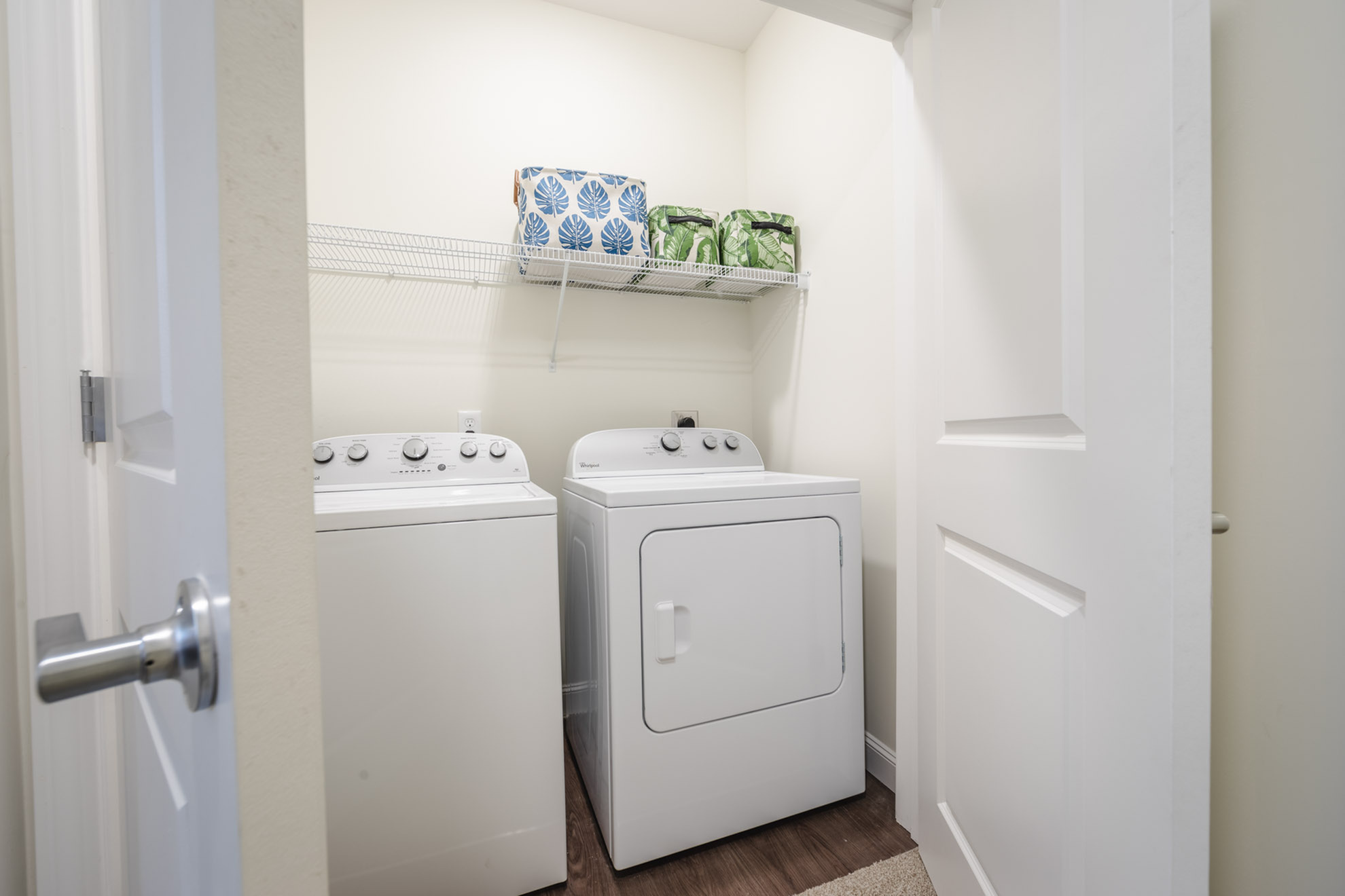 Modern laundry room featuring a sleek washer and dryer with elegant shelving for storage.