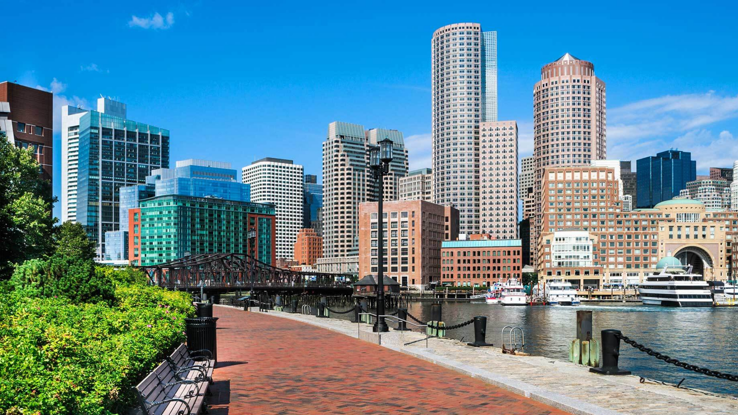 Vibrant city skyline with modern waterfront buildings and lush greenery.