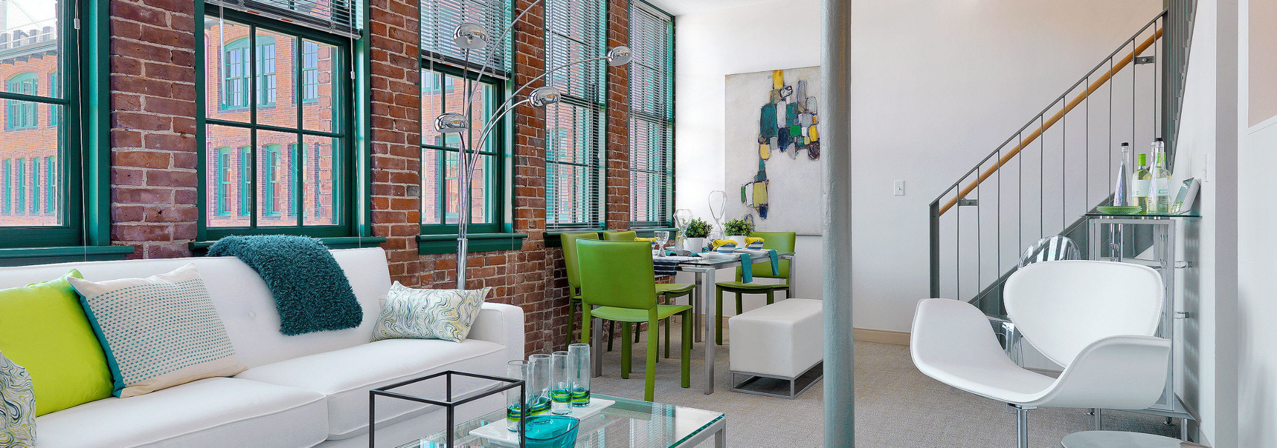Watch Factory Lofts | Bright loft apartment with exposed brick walls, modern furniture, and large windows. | Apartments for rent near boston ma