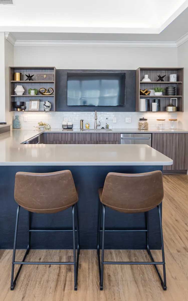 Contemporary kitchen with sleek countertops, stylish bar stools, and elegant open shelves, perfect for modern living.
