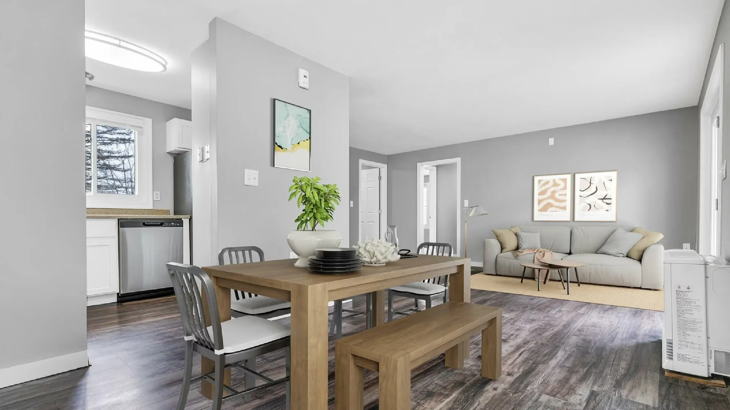 Modern open-concept living and dining area with sleek grey walls, hardwood floors, stylish furniture, and bright natural light.