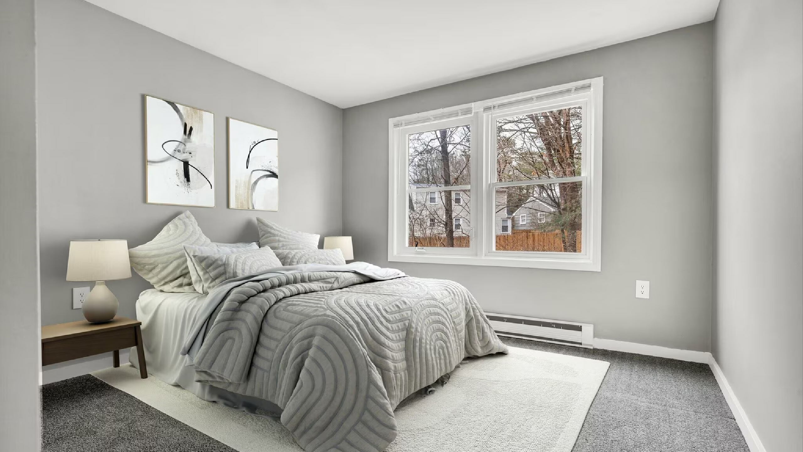 Bright and inviting bedroom with modern decor, featuring a plush bed, stylish artwork, and large windows offering a charming neighborhood view.