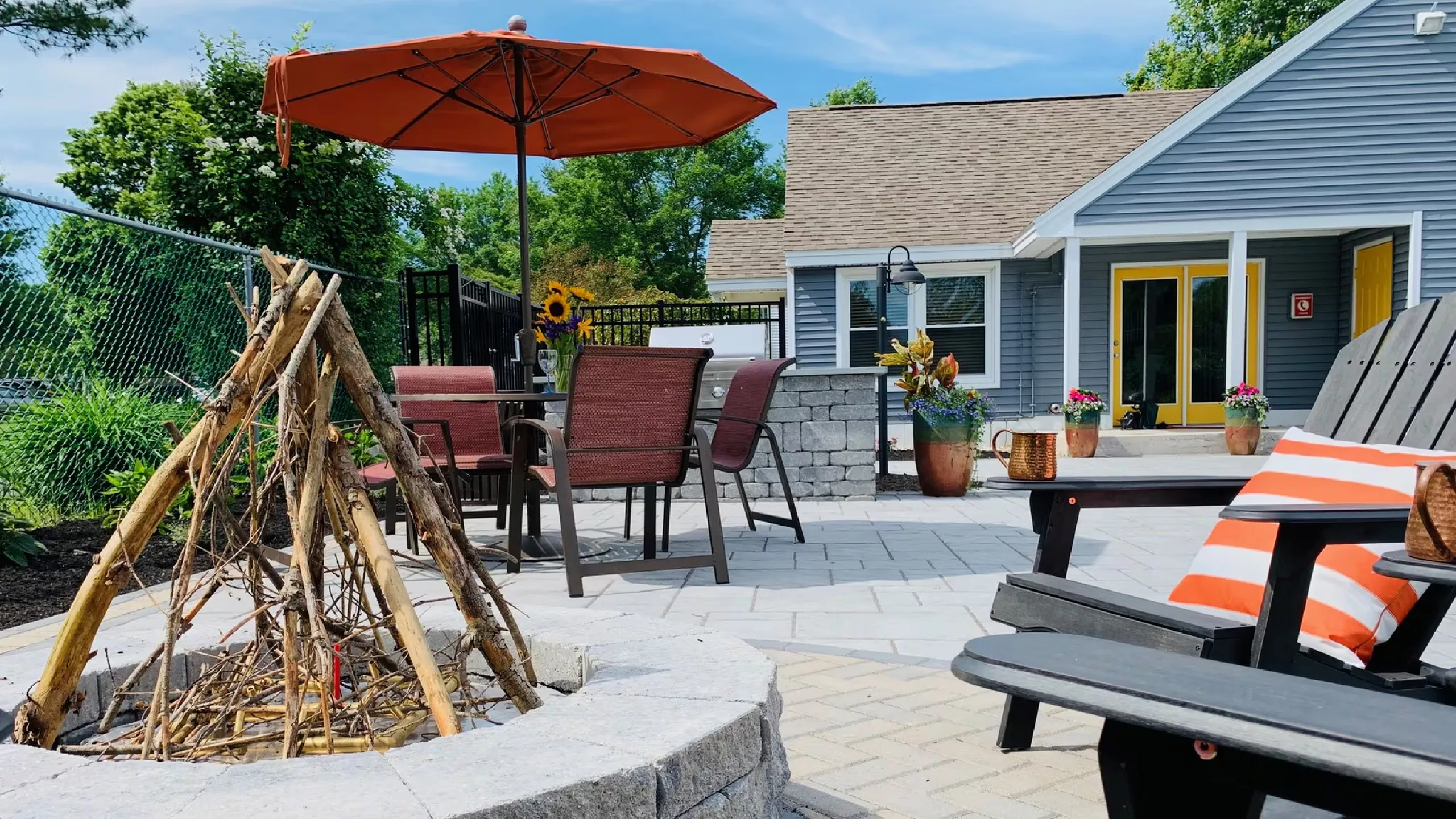 Inviting outdoor patio with cozy fire pit, modern seating, and vibrant flowers, perfect for entertaining and relaxation.