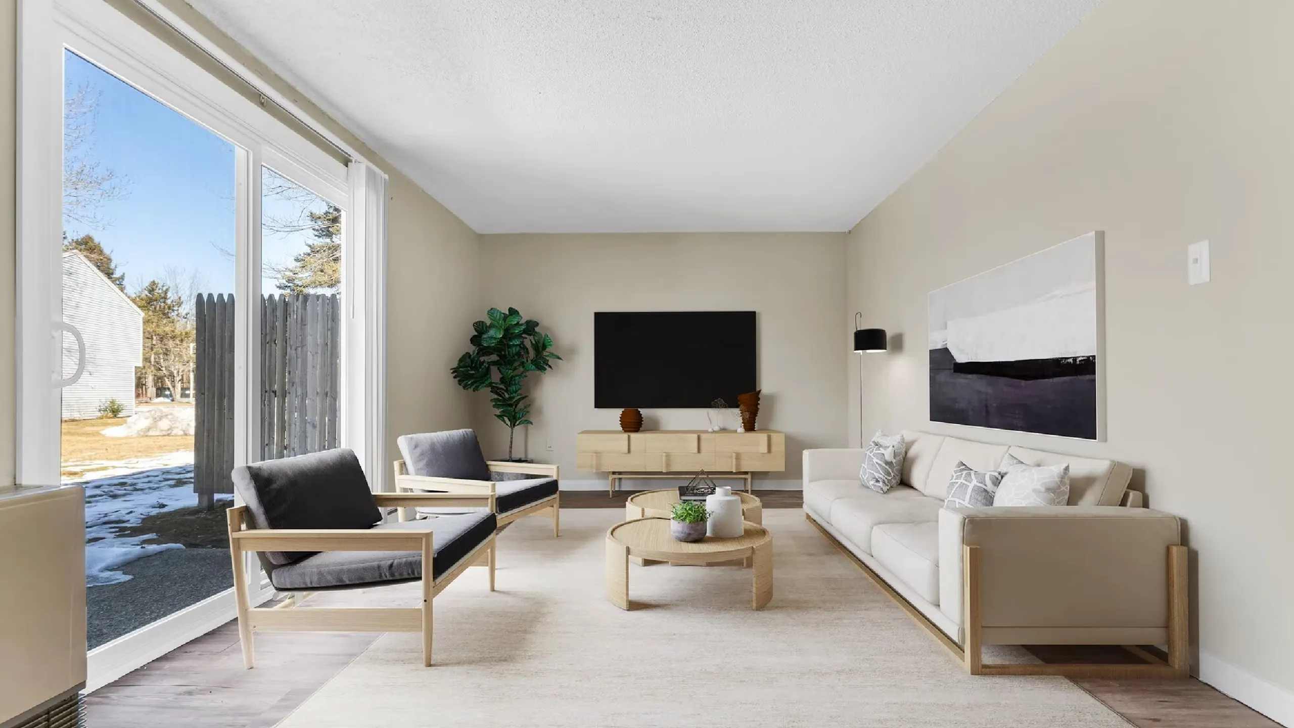 Elegant living room with minimalist decor, featuring large windows with a view, cozy seating, and a sleek entertainment center.