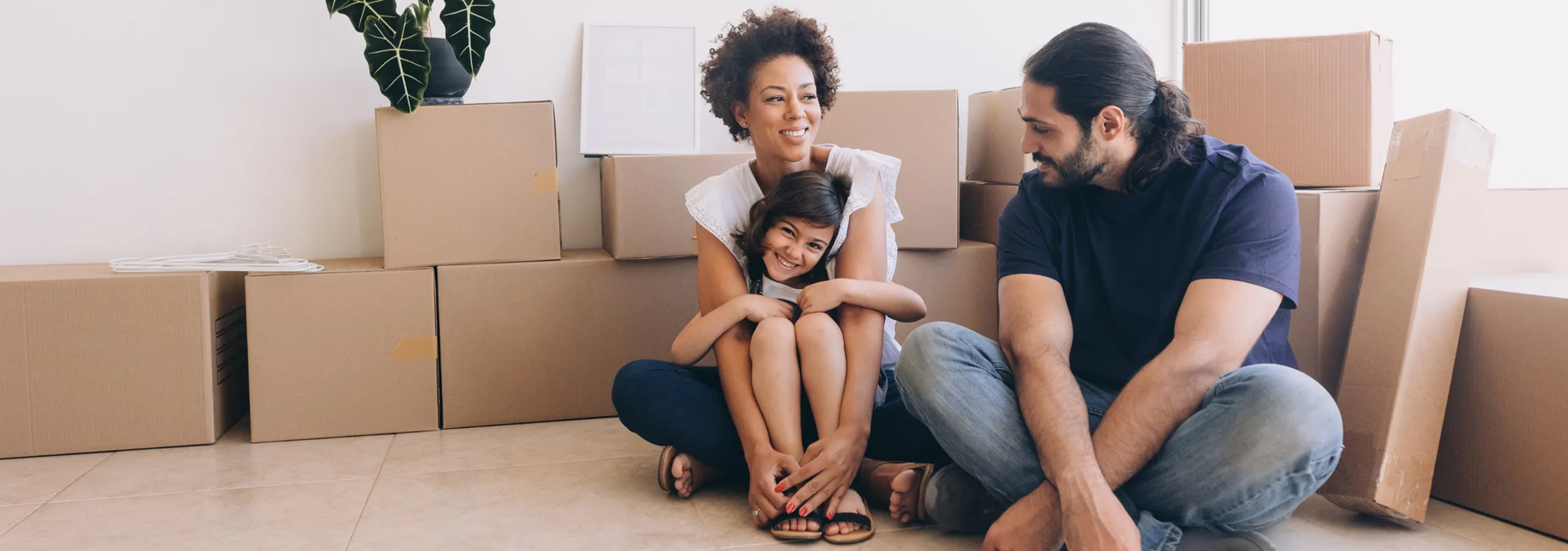Happy family enjoying their new home amidst moving boxes, showcasing a fresh start and family warmth.