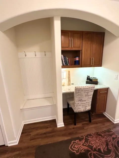 Cozy nook with elegant wooden cabinets, a stylish writing desk, and a comfortable chair, perfect for work or study in a modern apartment.