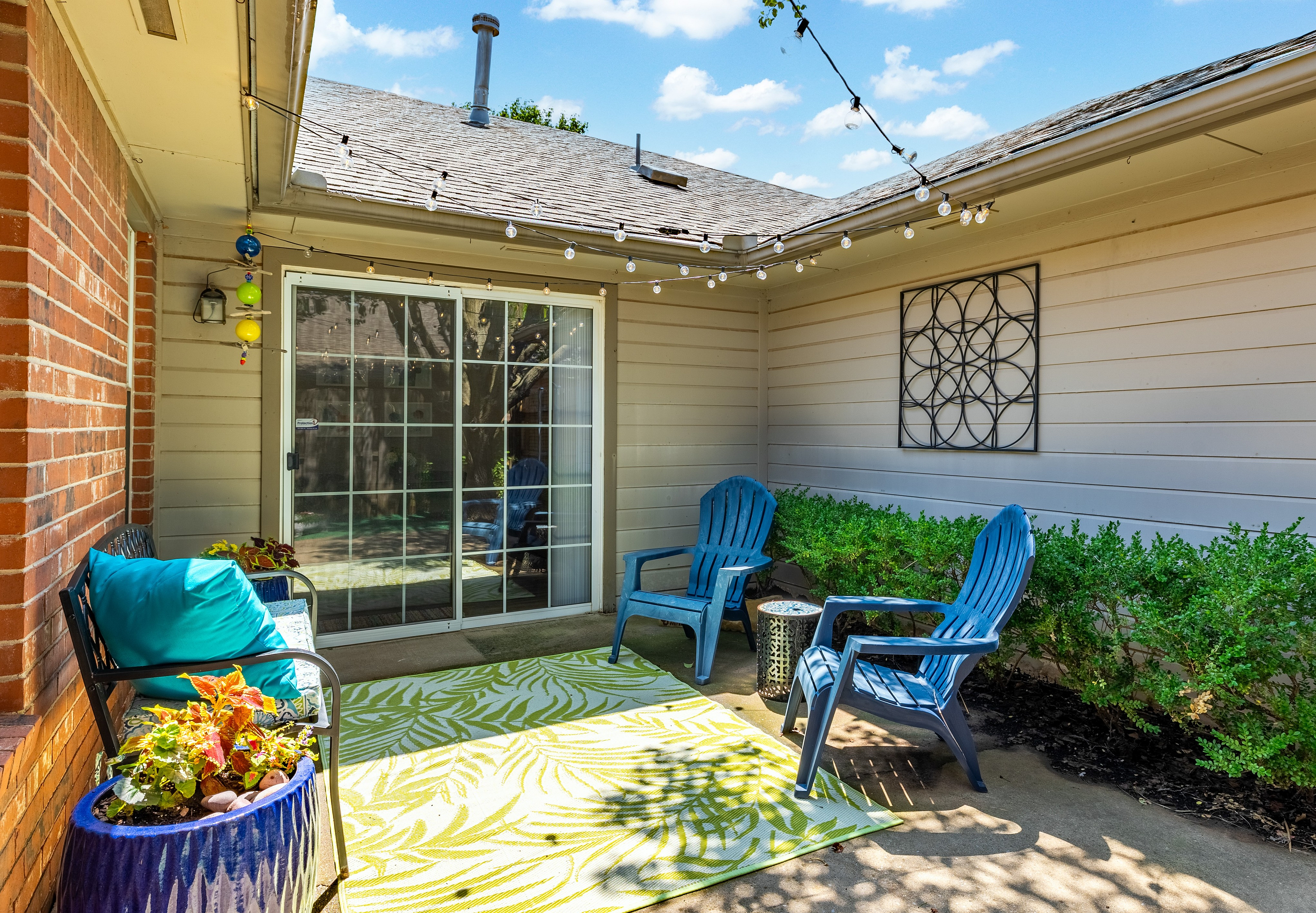 Charming outdoor patio featuring cozy seating, vibrant decor, and string lights creating a perfect relaxation space.