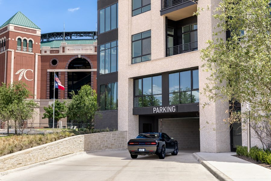 Contemporary apartment building with convenient parking located near a vibrant stadium, offering an urban lifestyle in a dynamic community.