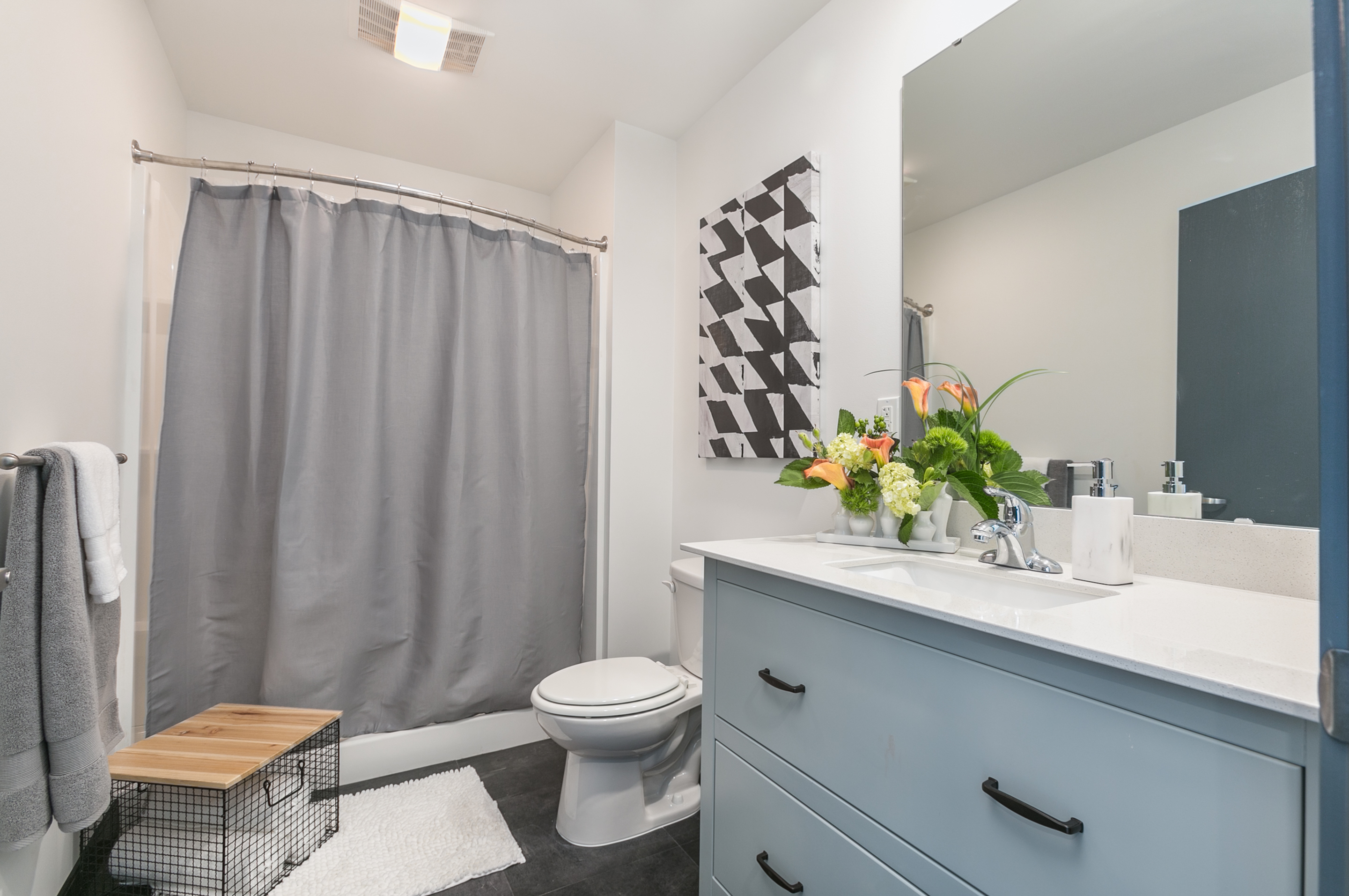 bathroom with blue cabinets and blue shower curtain