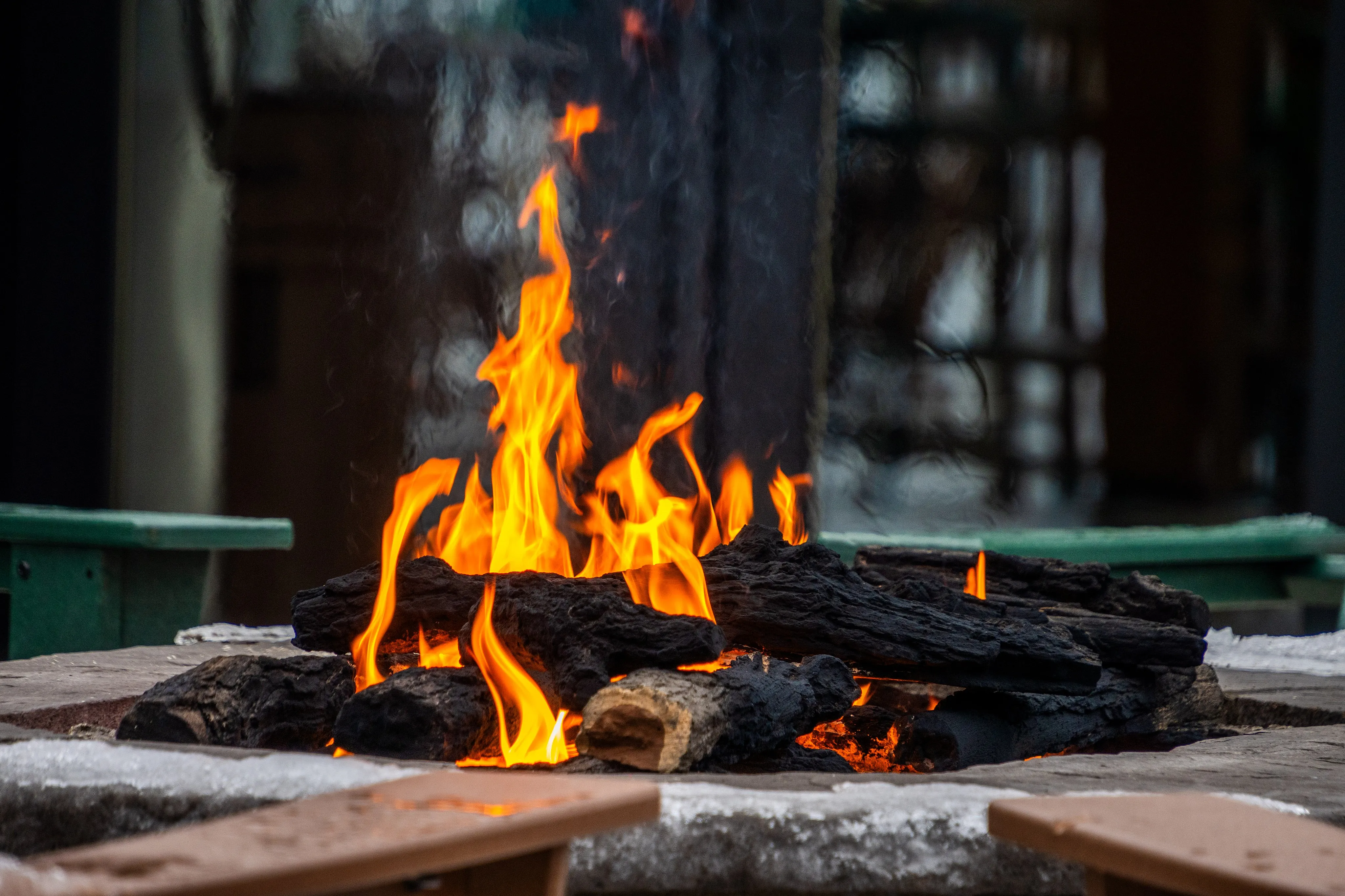 Inviting outdoor fire pit with glowing flames surrounded by rustic seating.