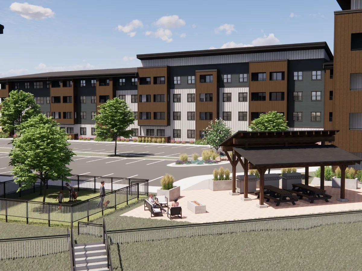A modern apartment complex with a recreational area, green landscaping, and inviting outdoor seating.