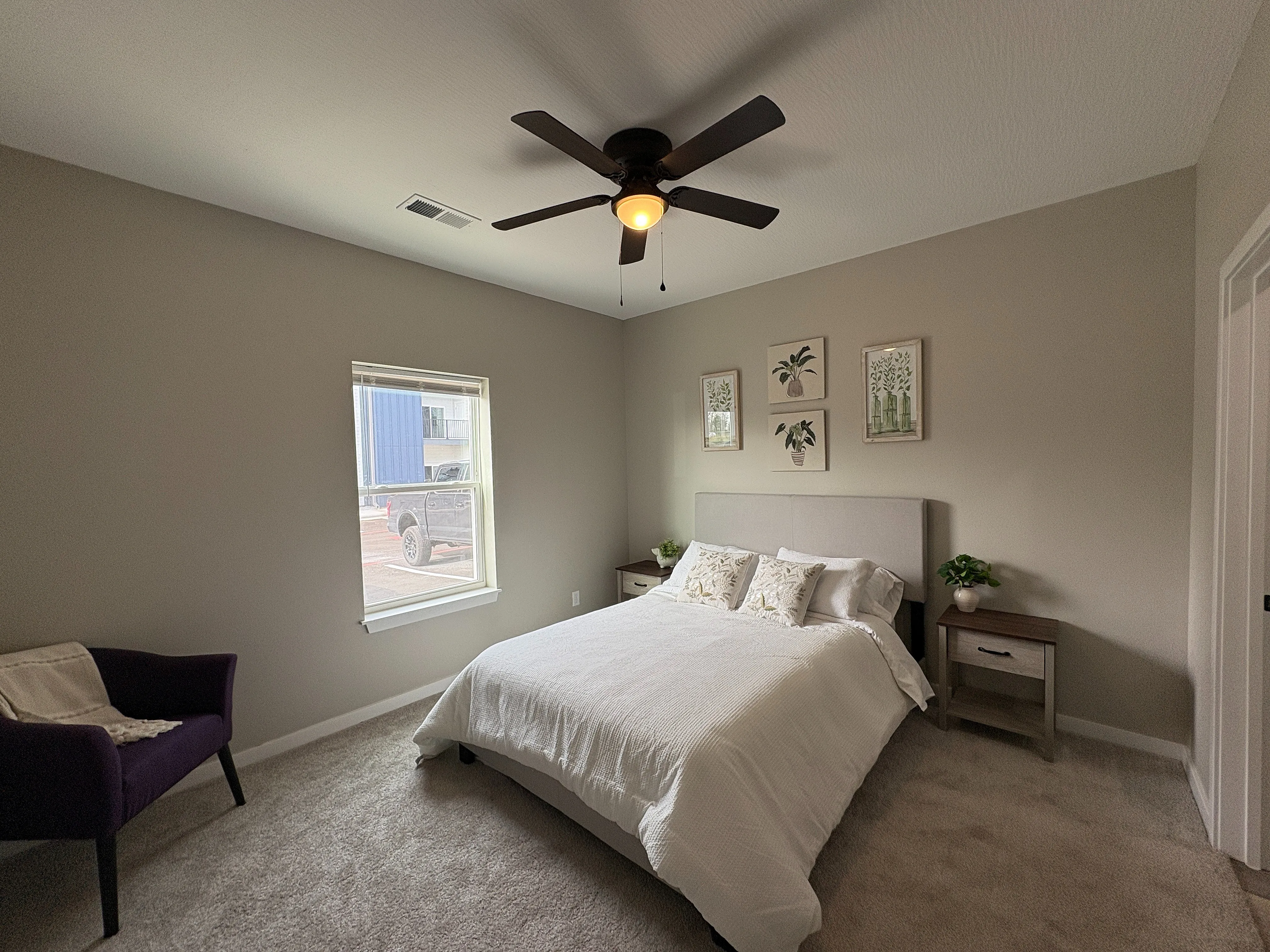 Chic bedroom with elegant decor, featuring a cozy bed, stylish side tables, and tranquil wall art, inviting a serene and comfortable ambiance.