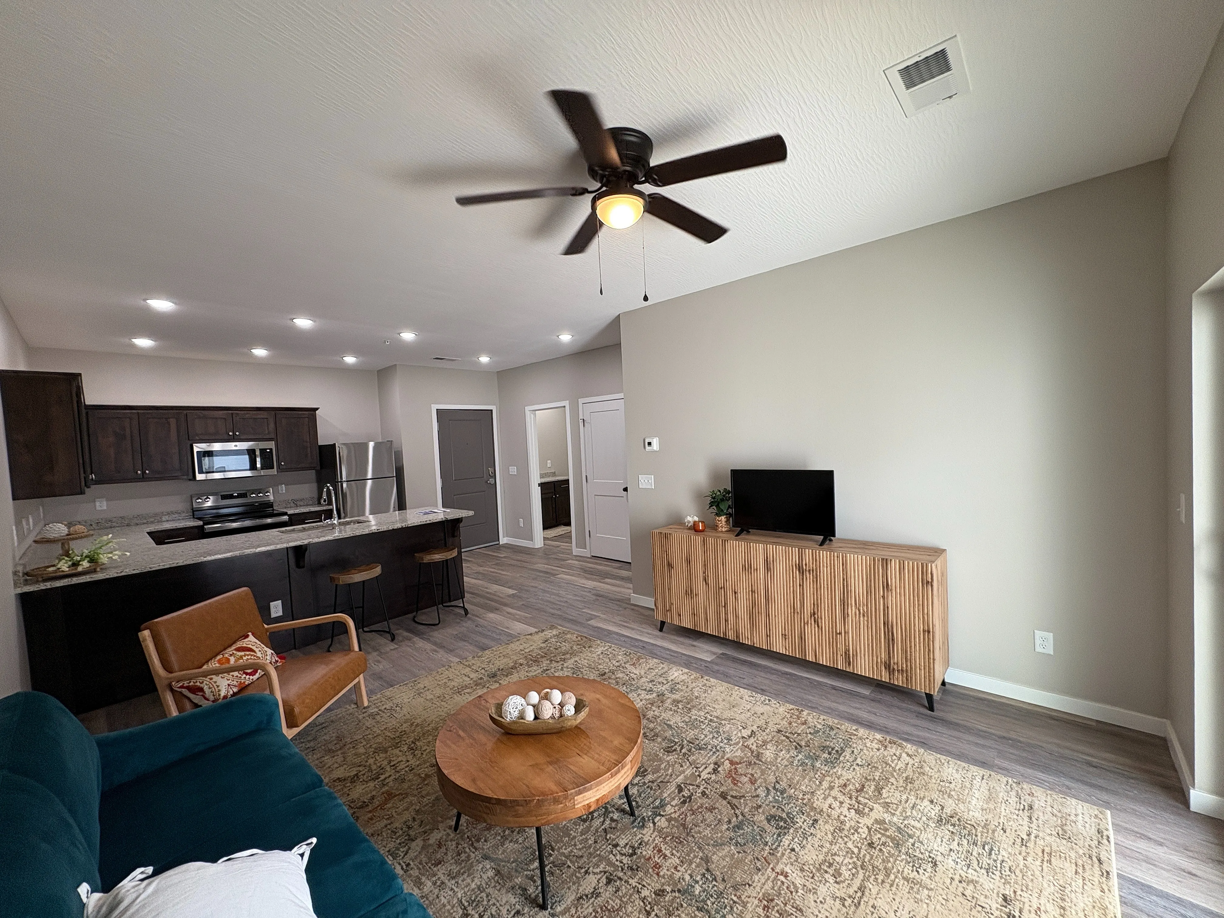 Contemporary open-concept living room with stylish kitchen, cozy seating, and elegant decor, ideal for modern living.