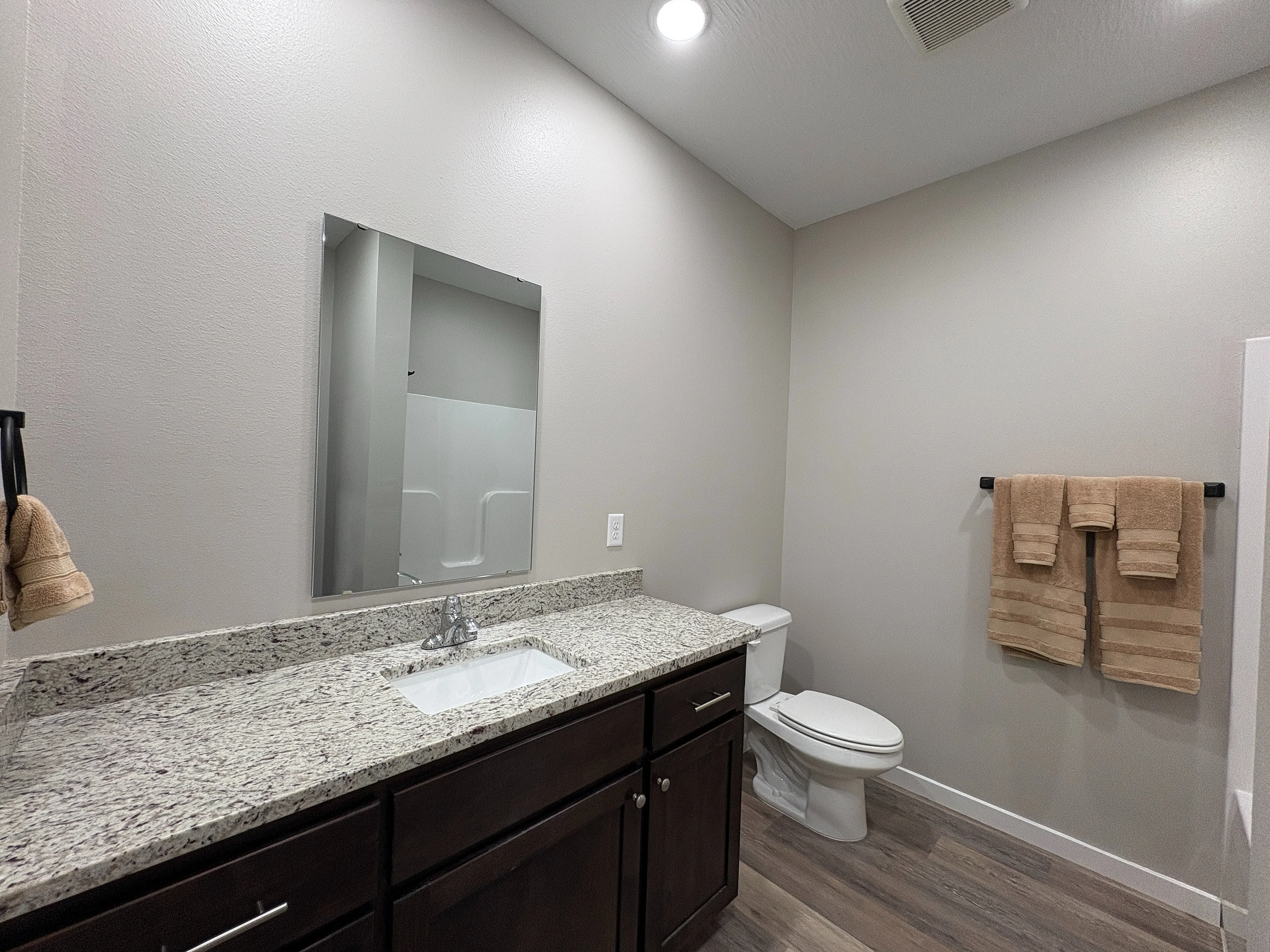 Modern bathroom with sleek granite countertop, elegant sink, and contemporary fixtures, exuding a stylish and inviting ambiance.
