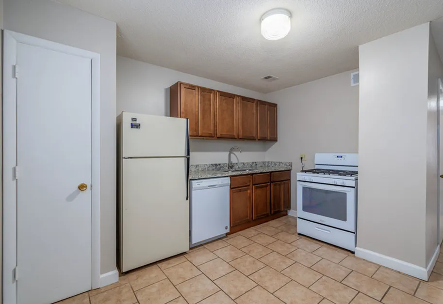 Inviting kitchen with modern appliances, wooden cabinetry, and a spacious layout perfect for cooking enthusiasts.