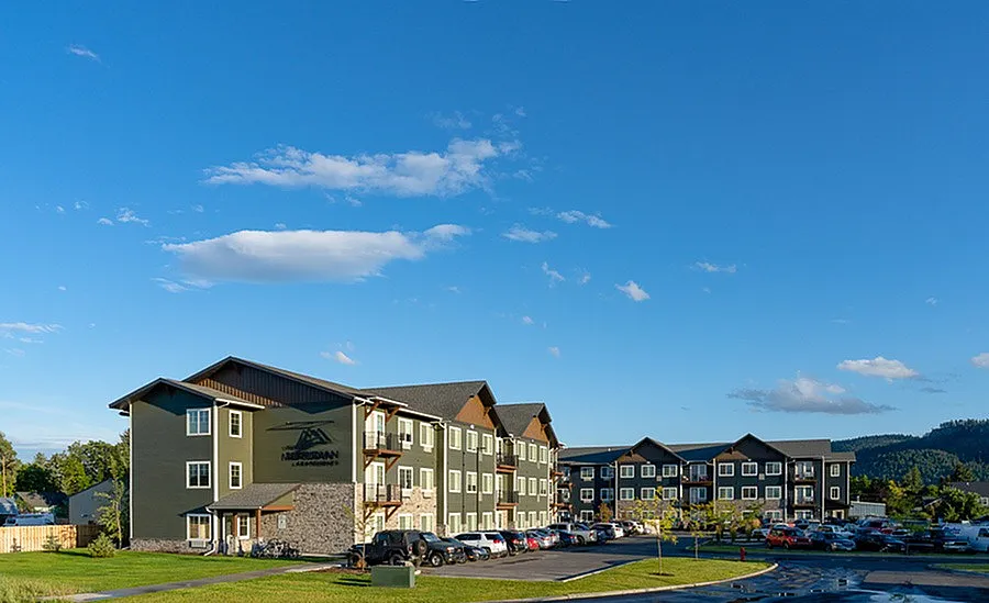 Charming apartment complex set against a clear blue sky, featuring modern architecture and scenic surroundings.