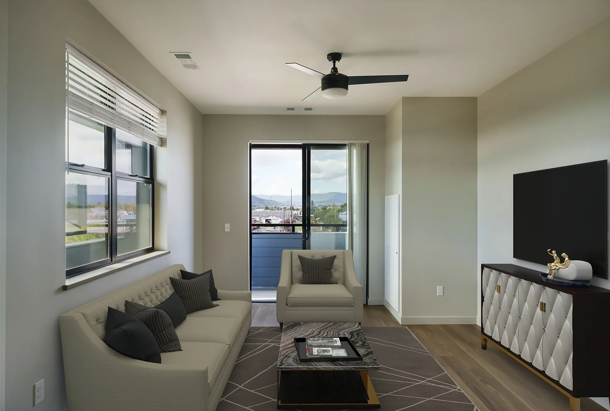 Modern living room with chic furnishings and a large window offering stunning views, perfect for relaxation and entertaining.
