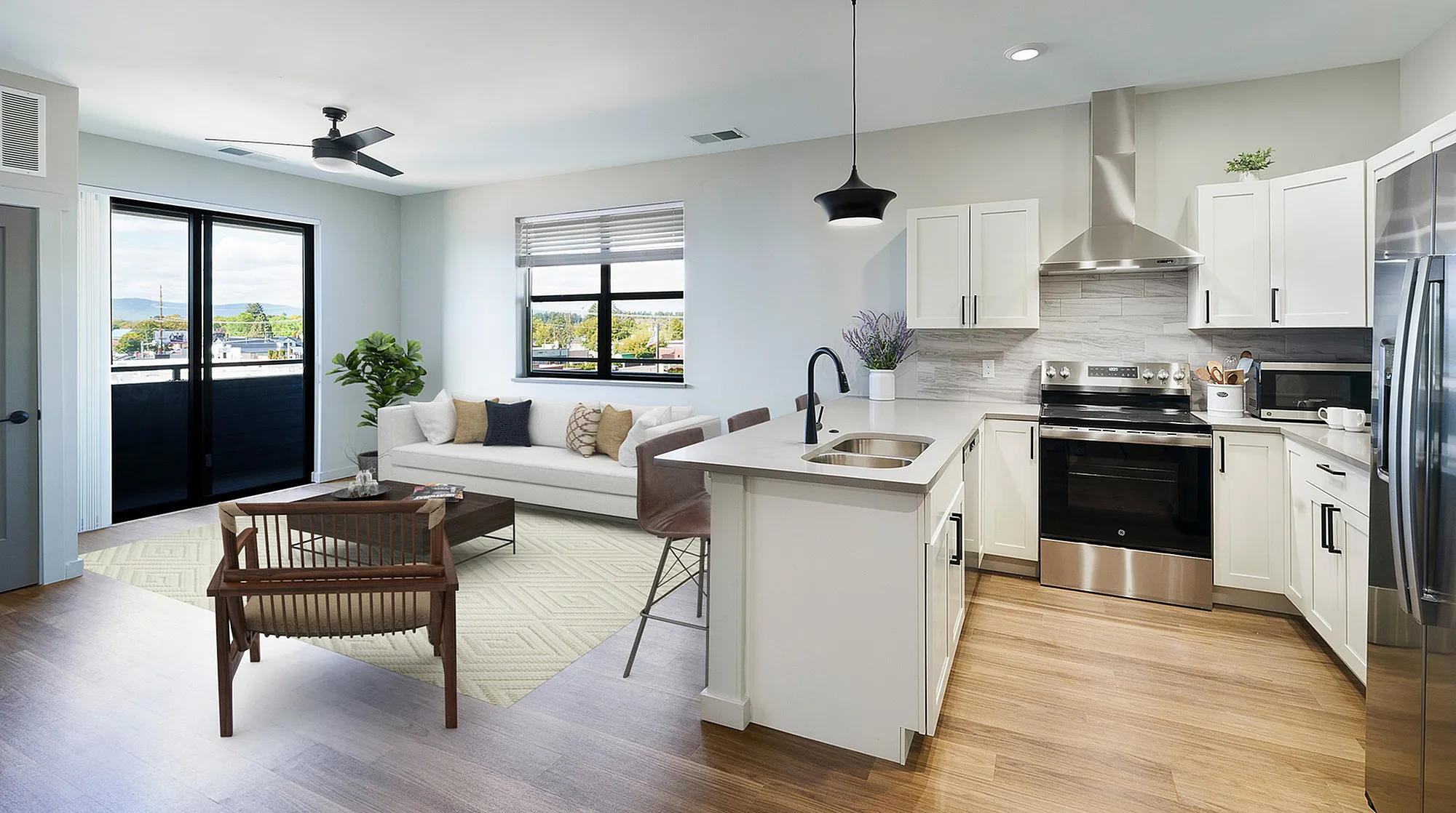 Modern open-concept living area with sleek kitchen, cozy seating, and large windows offering scenic views.