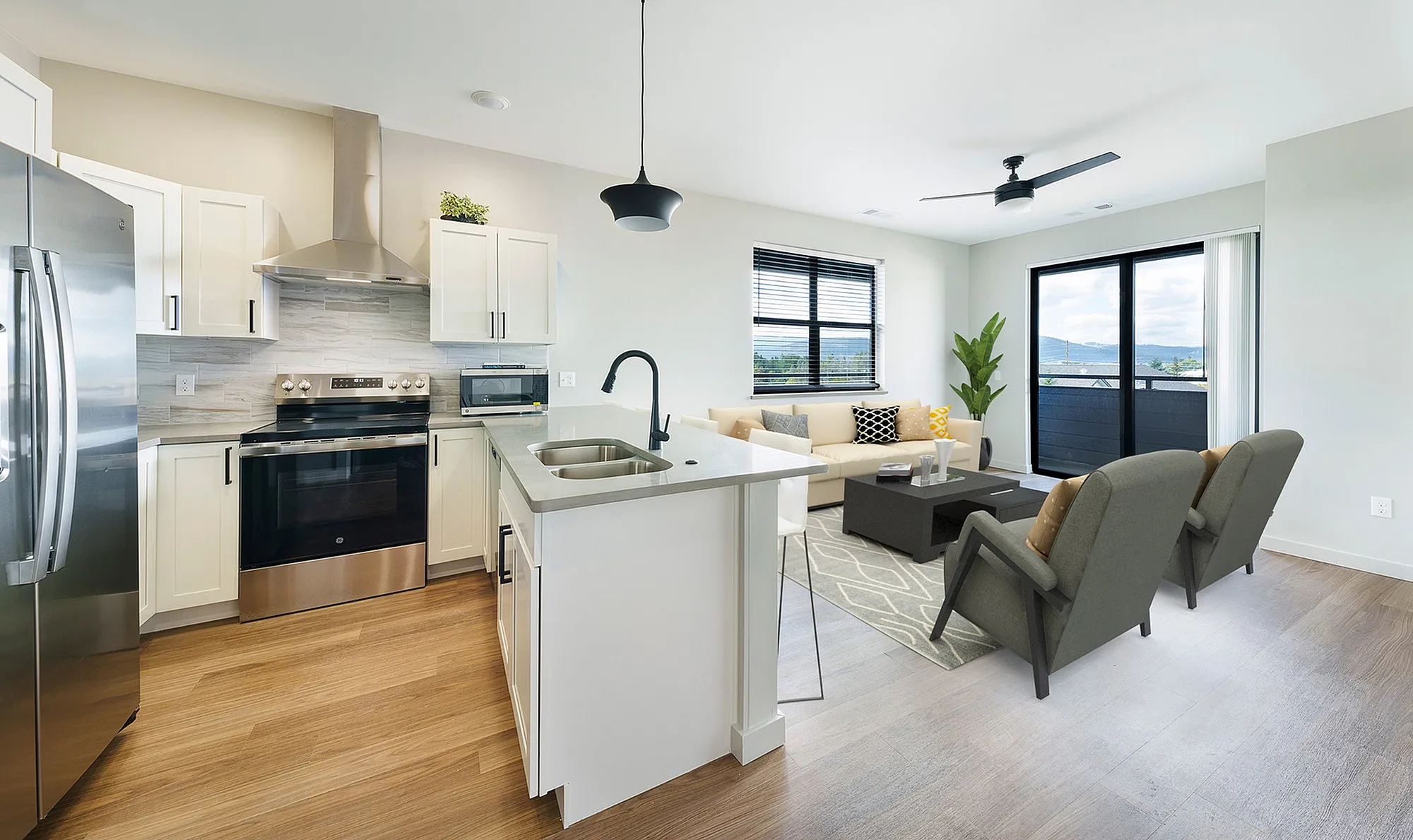 Modern open-concept kitchen and living room with sleek appliances, elegant cabinetry, and a luminous seating area with large windows offering scenic views.