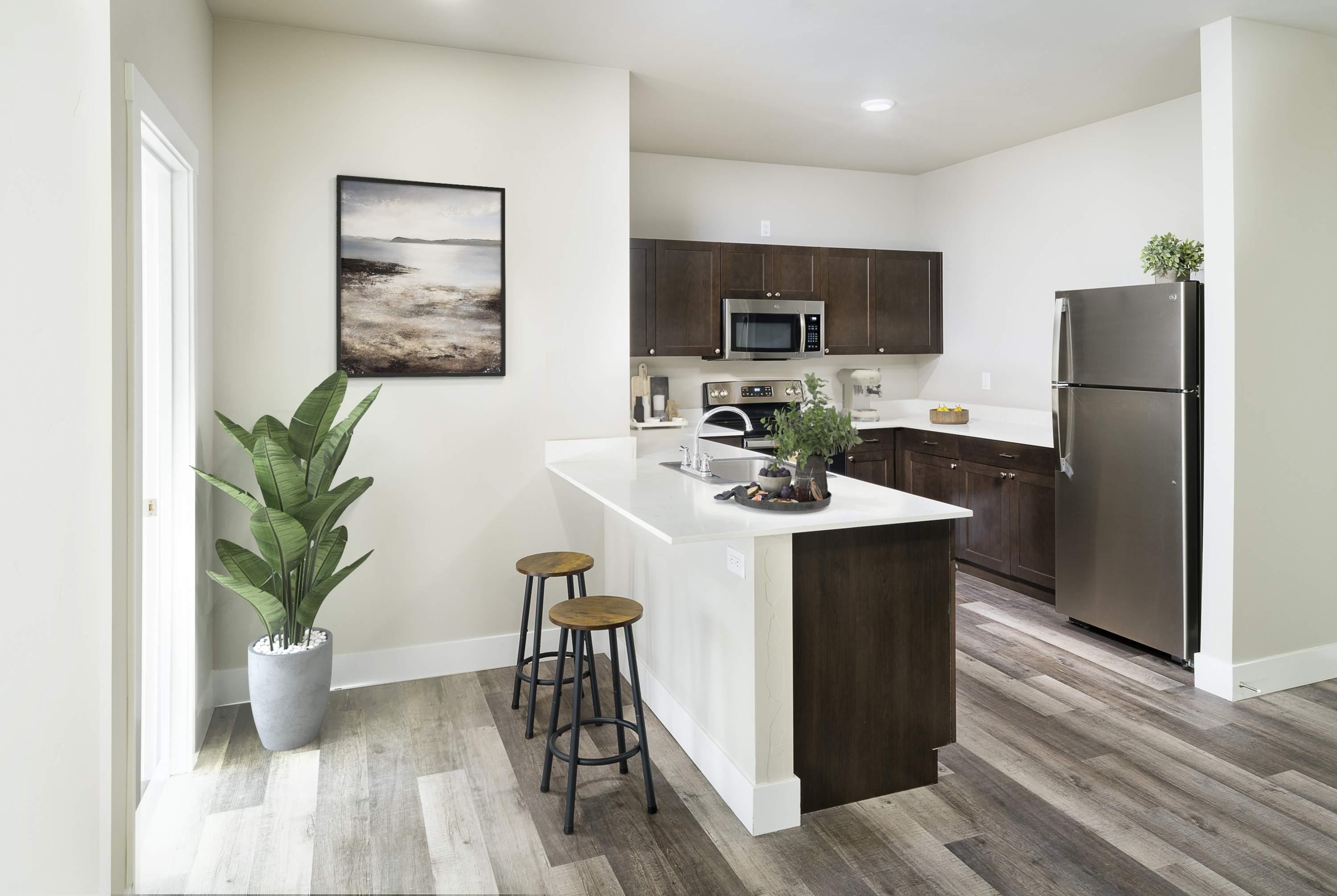 Bright and modern kitchen with sleek countertops, stainless steel appliances, and cozy bar seating, ideal for entertaining.