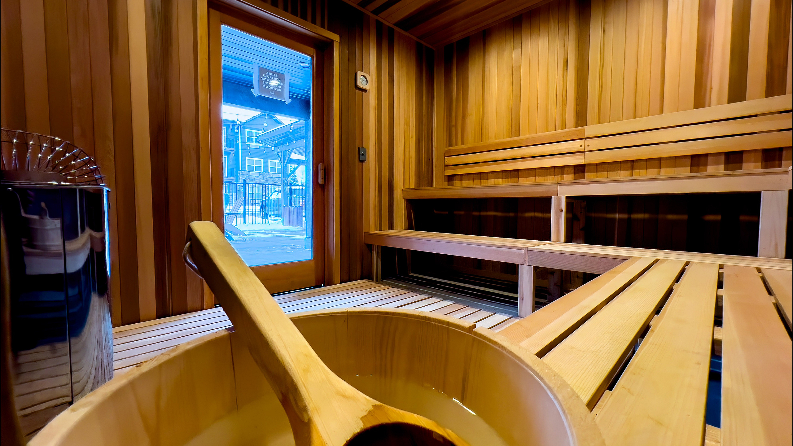 Inviting wooden sauna interior featuring warm lighting and traditional wooden benches.